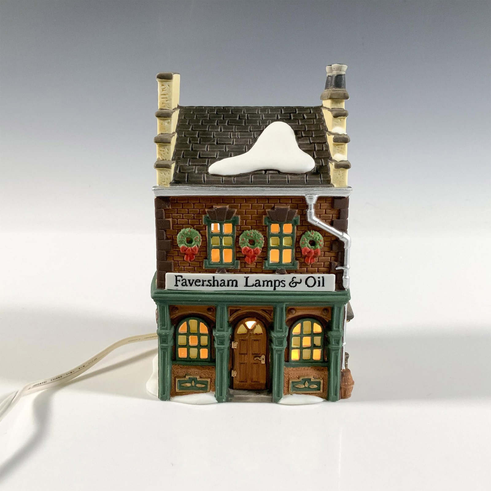 Dept 56, Faversham Lamps & Oil Dickens Village: This festive intricate snow village build is stunning. This figurine was made in 1995 out of ceramic and porcelain material. Hand made and hand-painted. Backstamped Dickens' Village Series, Faversham 