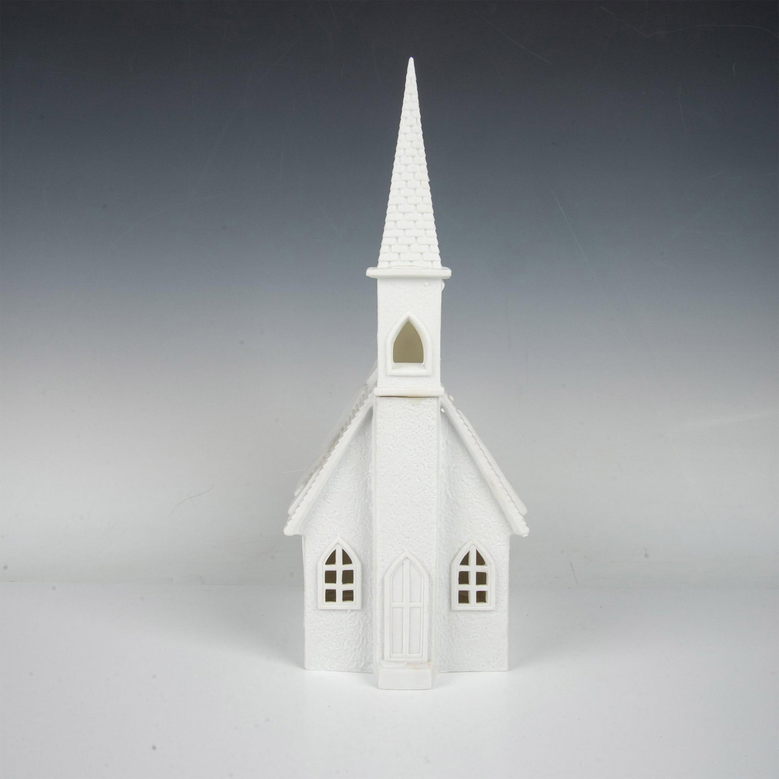 Department 56 Figure, Winter Silhouette Church: Matte white porcelain figure modelled as a church with a front steeple and snow on the roof. Department 56 backstamp. Includes bulb with wire. Includes original box 10"L x 7"W x 16.5"H. Dimensions: 8"