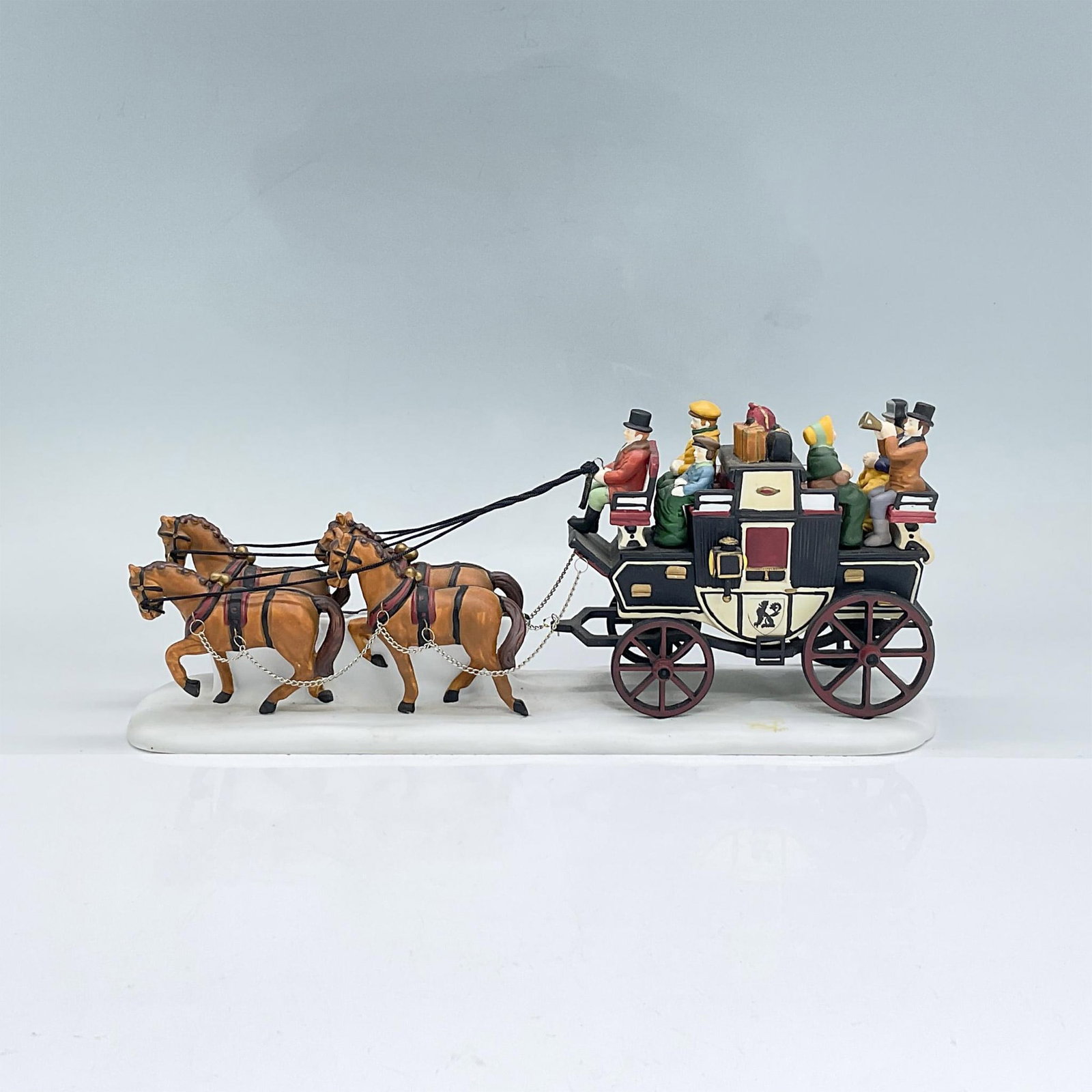 Dept 56 Heritage Village Collection Figural, Holiday Coach: Handpainted matte porcelain figural modelled as a horse drawn coach with four horses, a coachman and five passengers. Department 56 mark. Includes original box 13"L x 6.25"W x 4"H. Issued: 1991- 1998 
