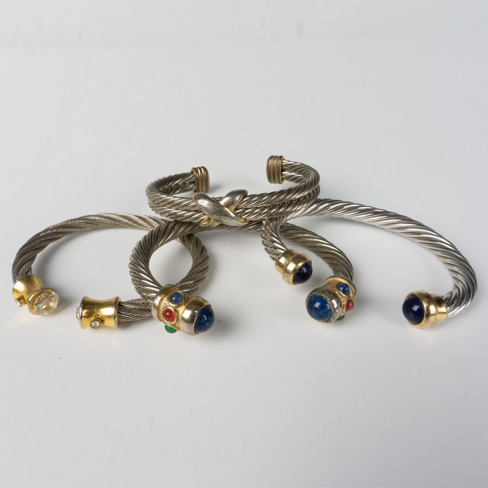 4pc David Yurman Style Twisted Two-Tone Metal Cuff Bracelets: Twisted silver metal bracelets with gold tone accents. They measure approximately 5.75"L around the inside with a 1.25" gap. Dimensions: See Description