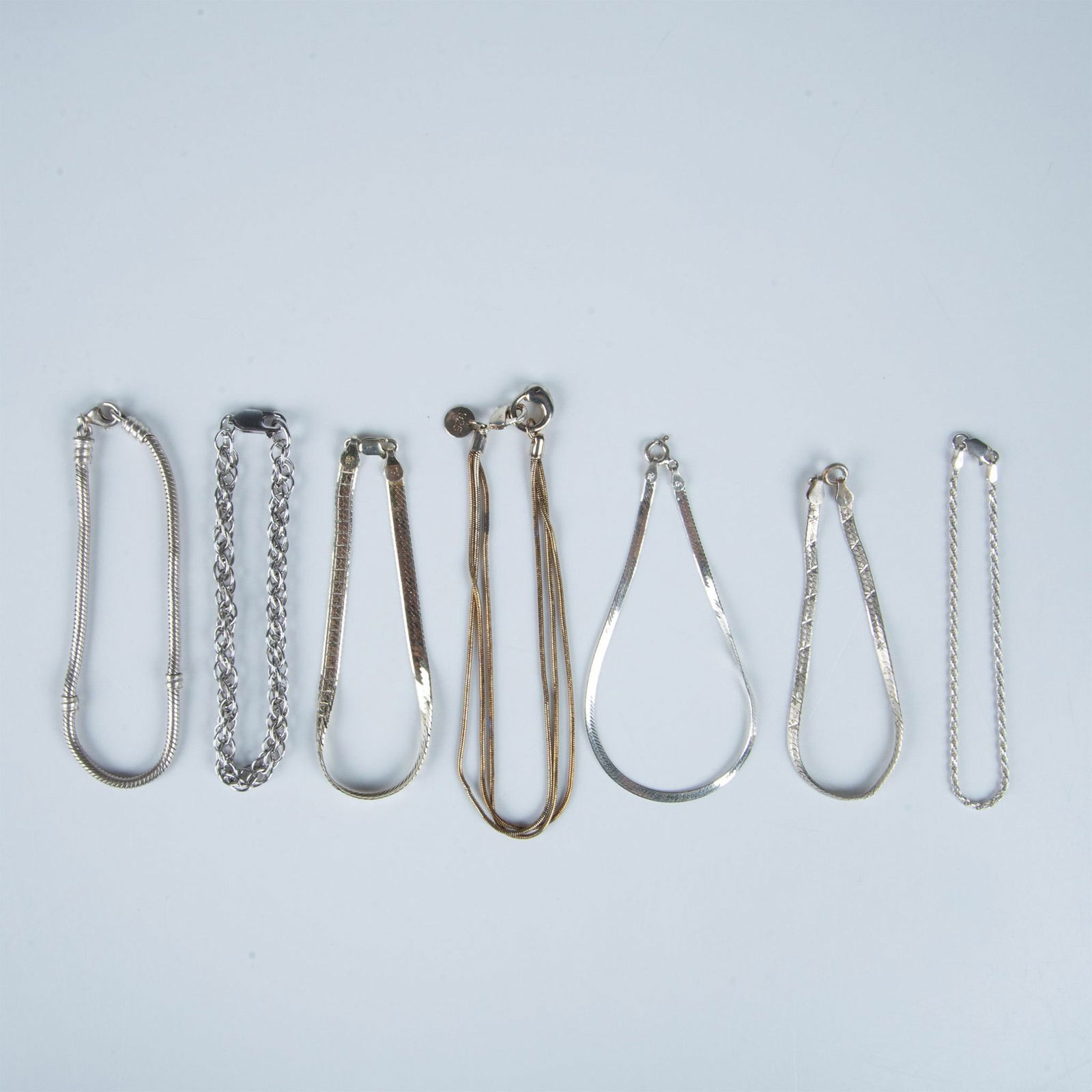 7 Sterling Silver Chain Bracelets: Seven beautiful marked sterling silver bracelets. The longest measures 9"L and the shortest measures 7"L. 40g total combined weight. Dimensions: See Description