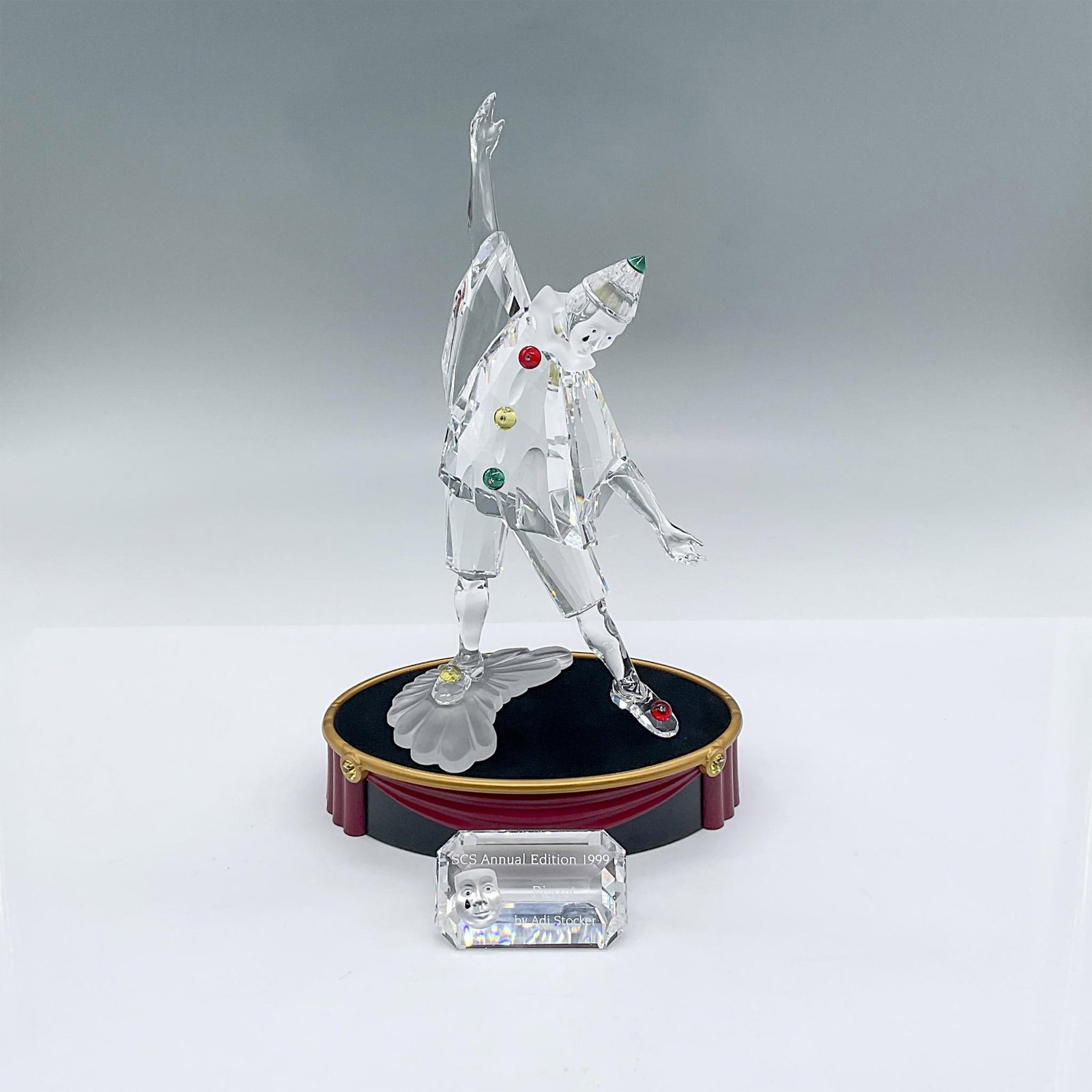 3pc Swarovski Crystal Figurine, Pierrot + Base + Plaque: This crystal piece is the first of the Masquerade trilogy. Designed of clear crystal with colored crystal accents on coat, hat and shoes. Face, collar and base is of satin crystal. Swarovski backstamp