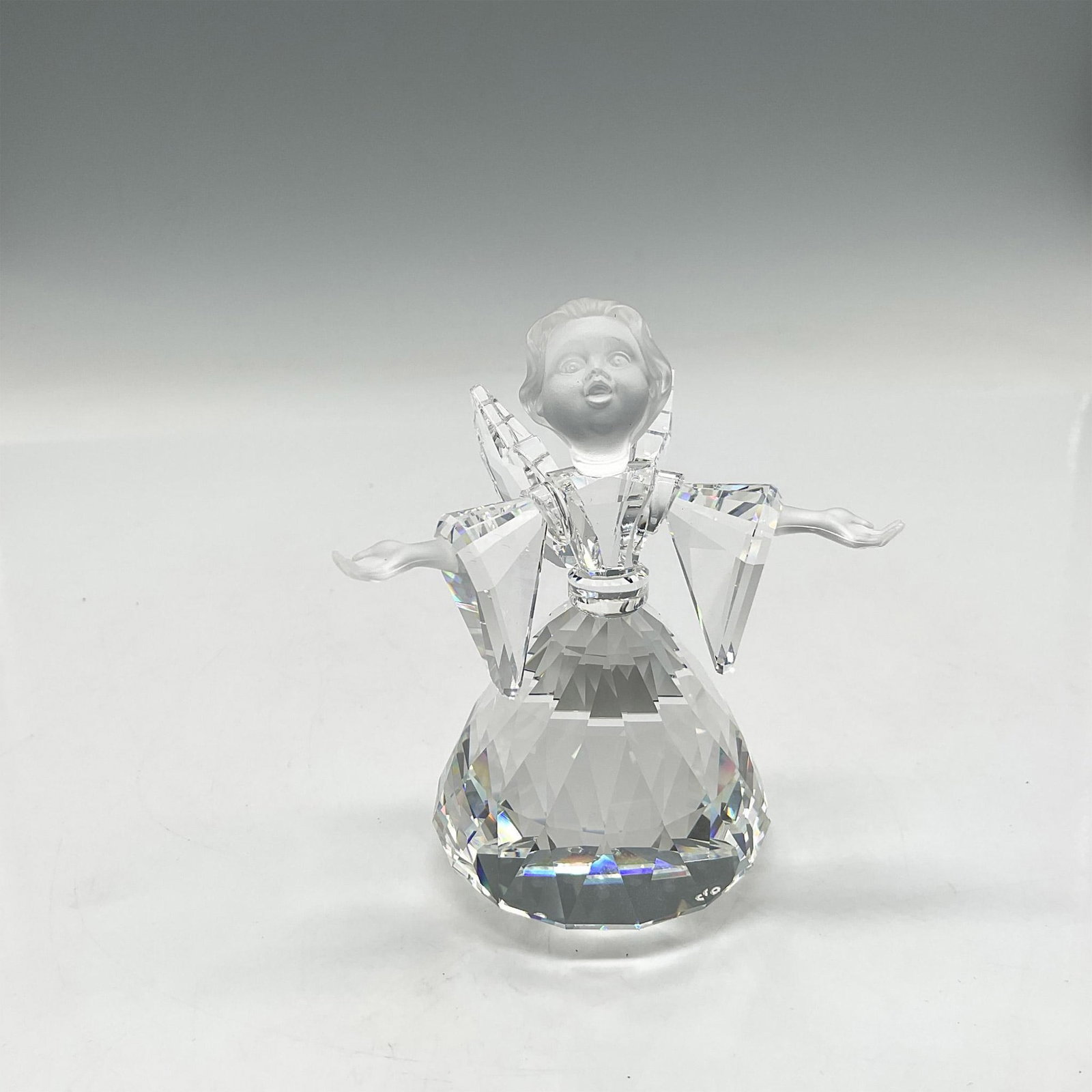 Swarovski Silver Crystal Figurine, Angel Large: Clear crystal figure with frosted face and hands. Part of the Cheerful Times theme group. Swarovski backstamp. 194761. This item has its original box: 5"H x 6" dia. Artist: Adi Stocker Issued: 1995-20