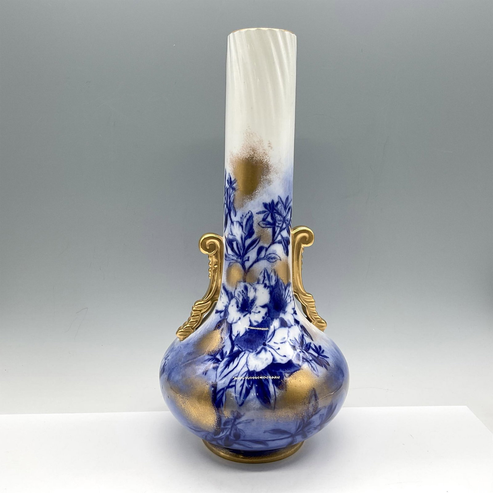 George Jones & Sons Porcelain Azalea Bulb Vase: Lovely long neck with full round base designed in cobalt blue florals, gilt accents and scrolled handles. GJ & Sons backstamp. Azalea. Issued: c.1800 Dimensions: 13"H x 6"W Manufacturer: George Jones 