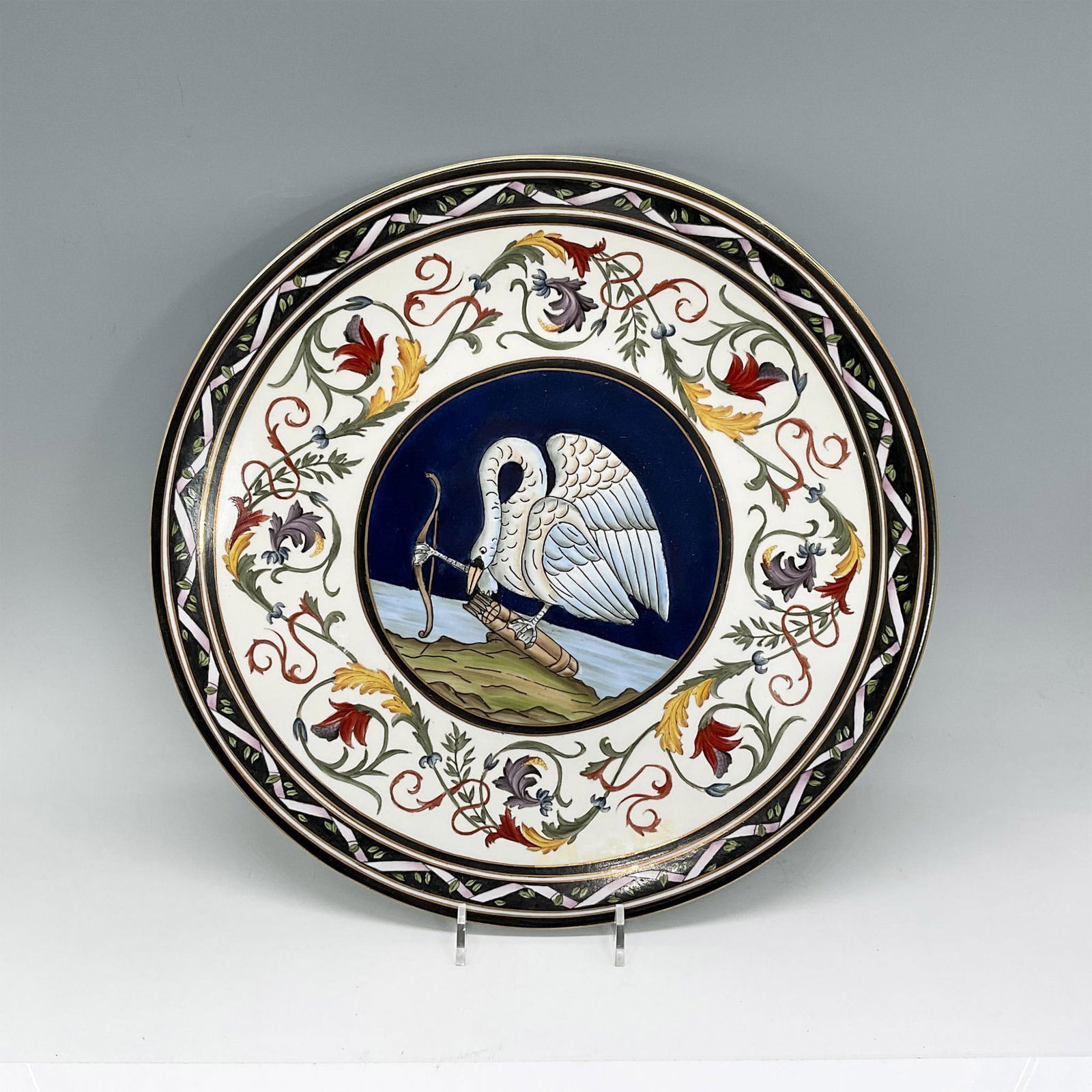 Vintage Ironstone Decorative Plate, Archer Swan: Interesting decorative plate featuring a swan holding a bow while looking down at the arrows. The border features flowers in red, yellow and purple. Gold rim and accents. Weight 3 lbs 9.2 oz. Dimensio
