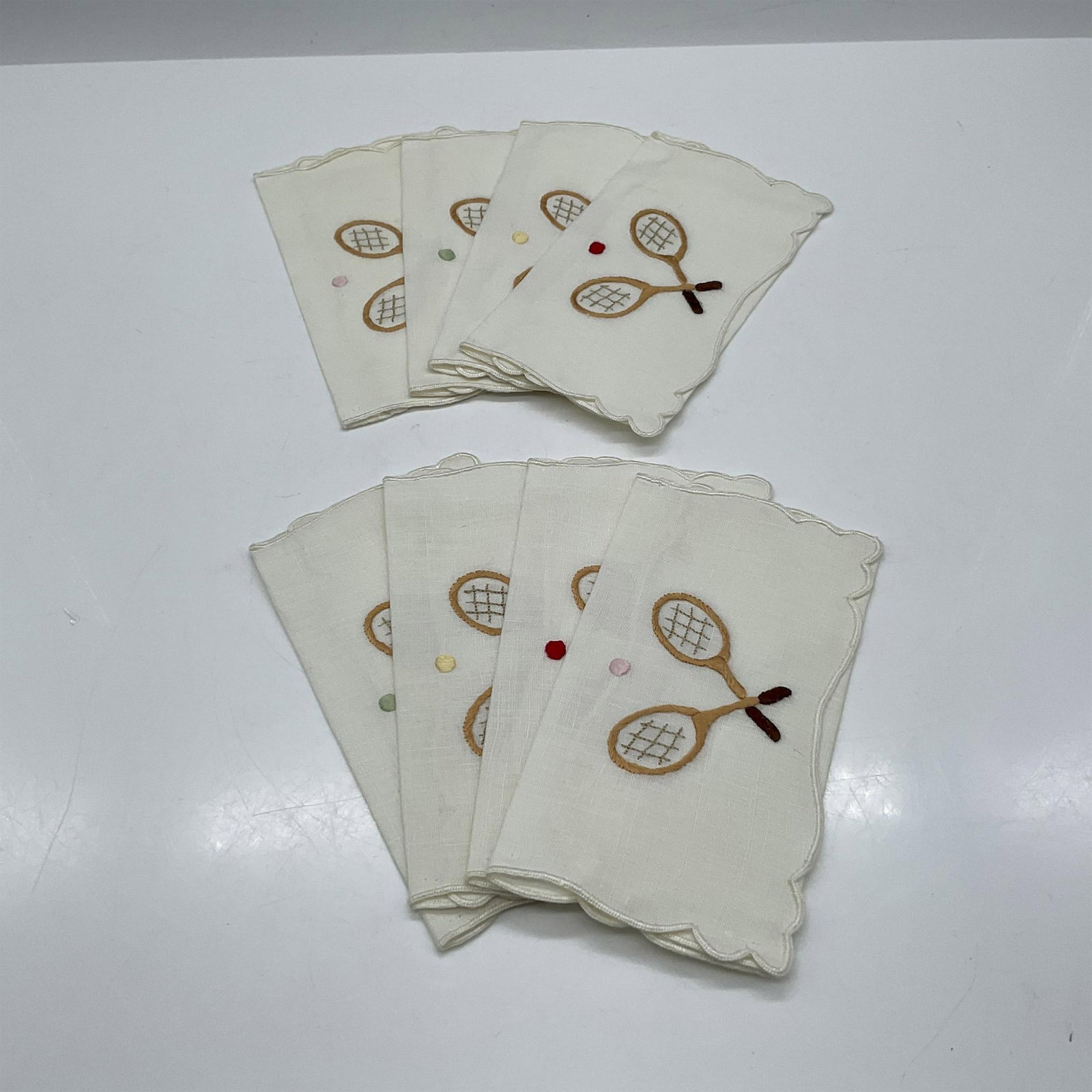 Embroidered Linen Handkerchiefs, Tennis, Set of 8: Tennis inspired embroidery with 2 rackets and ball on each handkerchief. Ball colored in red, green, yellow and pink. Issued: 20th century Dimensions: 7.5"L x 5"W