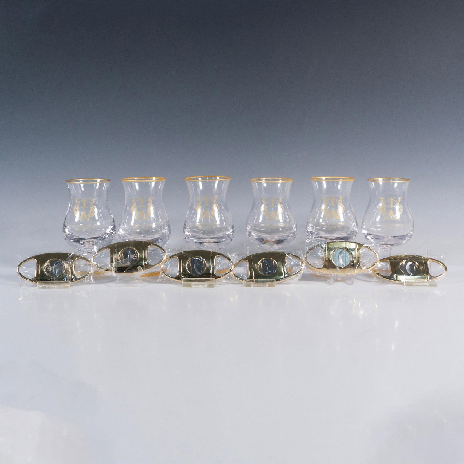 12pc The Craft Irish Whiskey Co. Finn Glass Set: This distinguished collection by The Craft Irish Whiskey Co. proudly showcases their logo and includes 6 Finn whiskey tasting glasses and 6 sleek cigar cutters, perfect for gifting at your next whiske
