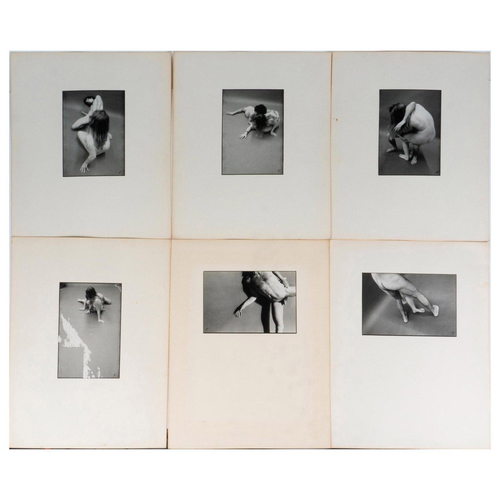 Set of 5 Original Black & White Photographs, Nudes, Signed: Set of five black and white mat photographs taken with a 35 mm camera. They depict a nude woman and a man in various sexual positions amidst a bare stage floor. Black ink signature on lower right: J. 