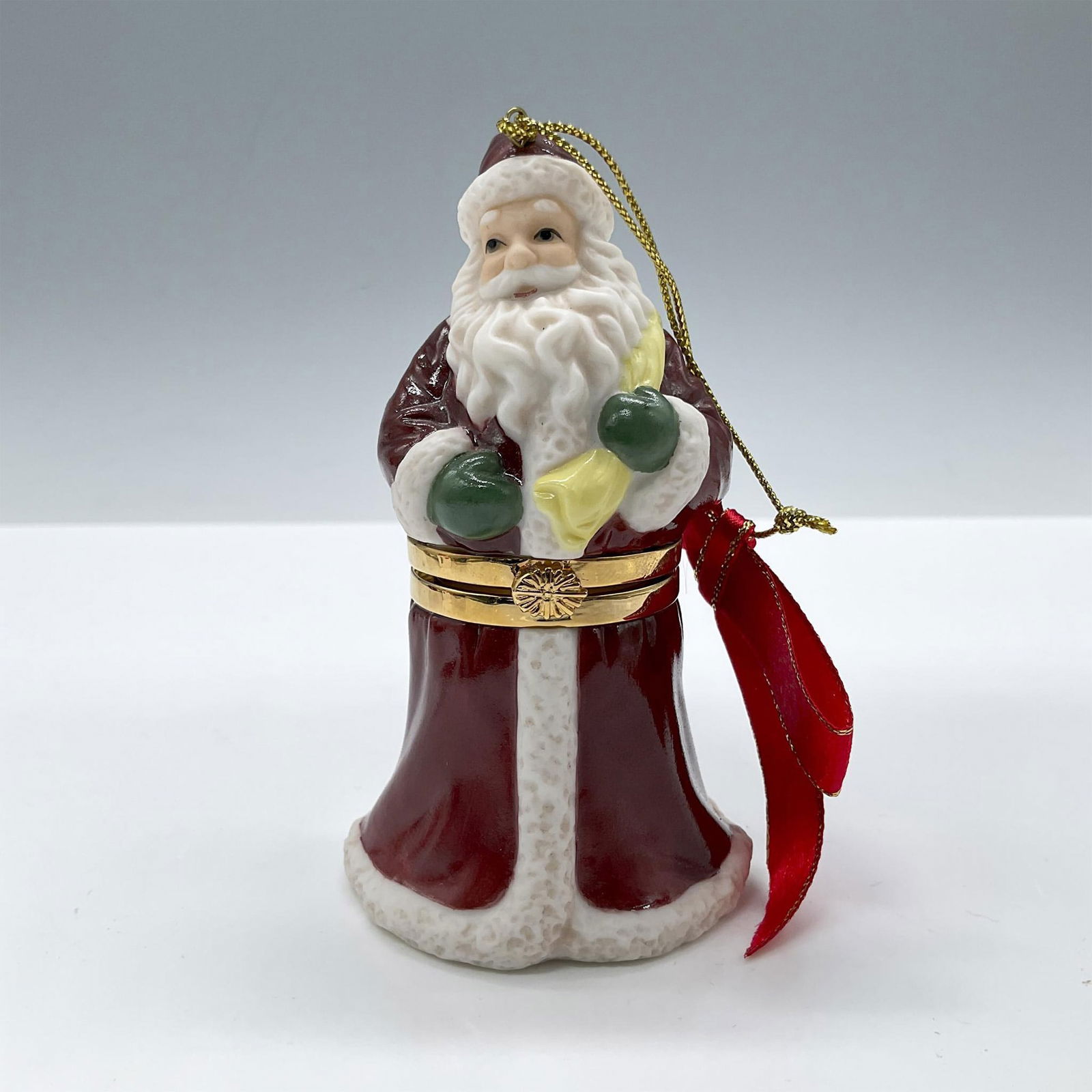 Spode Porcelain Treasure Box Ornament, Santa Claus: Glossy finish. Features a Santa Claus with a sack of toys. Completed by a gold closure and a red ribbon. Spode backstamp. Issued: 20th century Dimensions: 2''L x 2''W x 4''H Manufacturer: Spode Countr