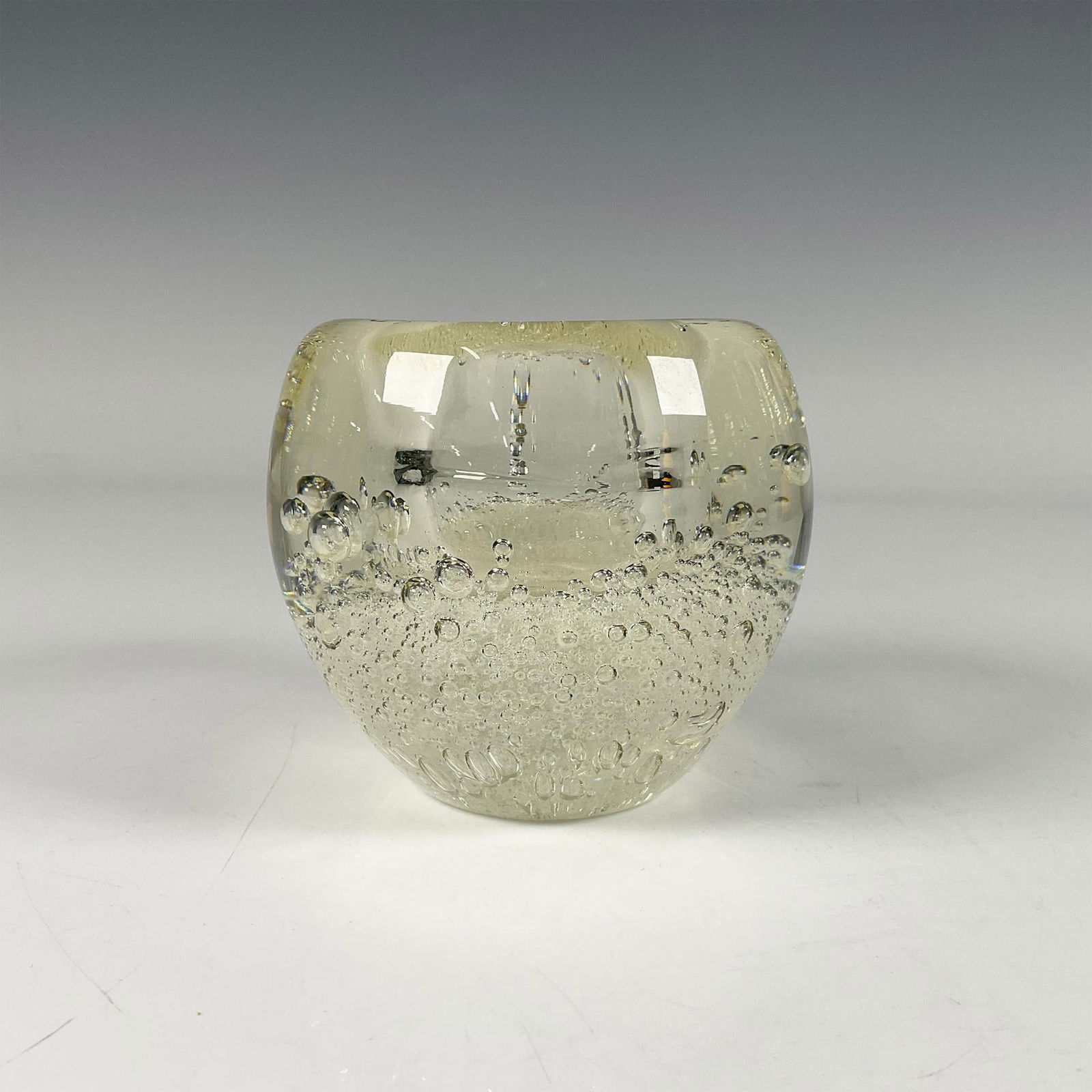 Bubble Art Glass Votive: A clear hand blown glass candle holder with bubbles all long the bottom and thick rounded edge. Dimensions: 3.5"W x 3.25"H