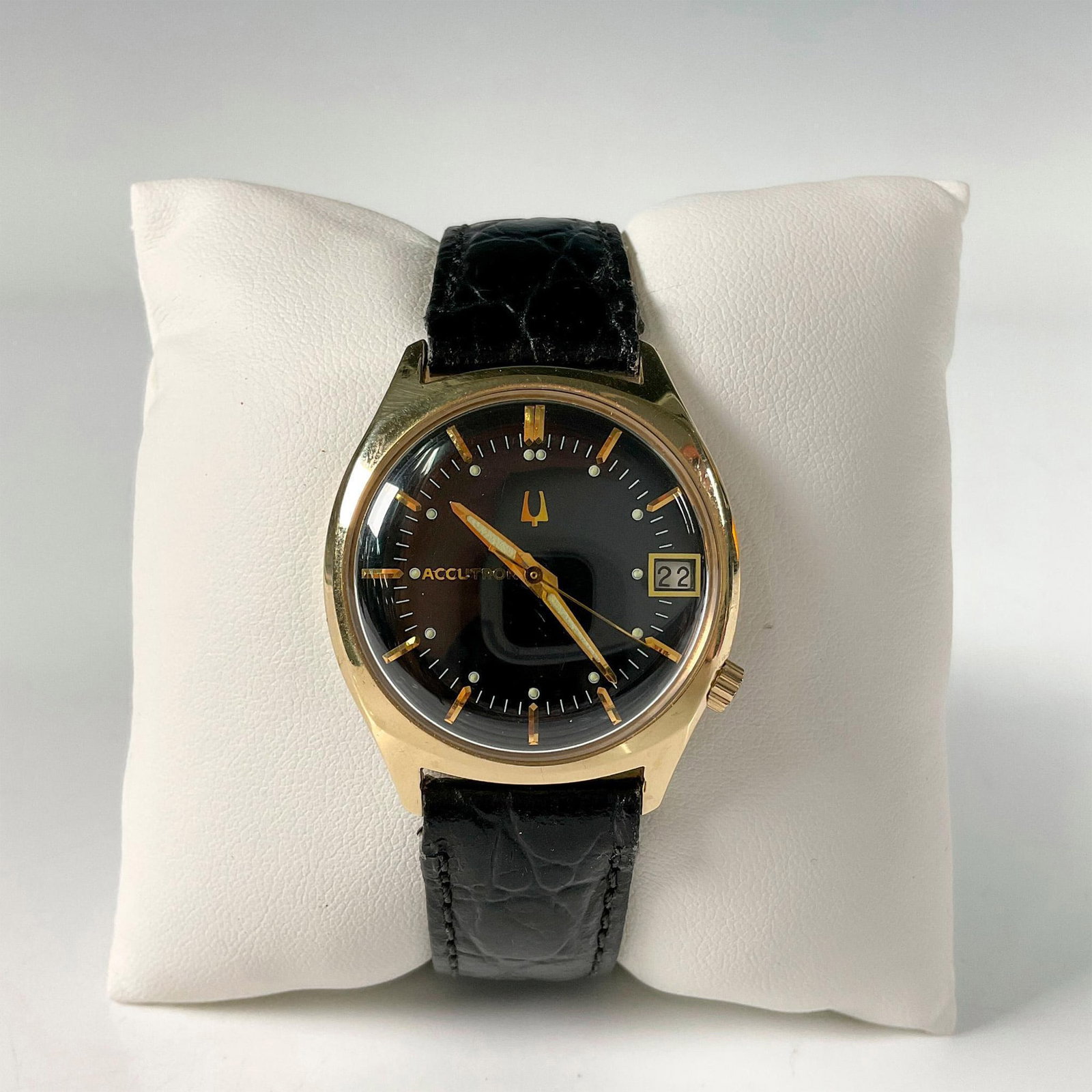 1969 Bulova Accutron Classic Gentleman 14KT Wristwatch: Iconic 1969 Bulova Accutron classic gentleman gold plated wristwatch with round dial. Features gold stick markers on a black face, a 14KT gold plated case and a day window with a black water-resistant