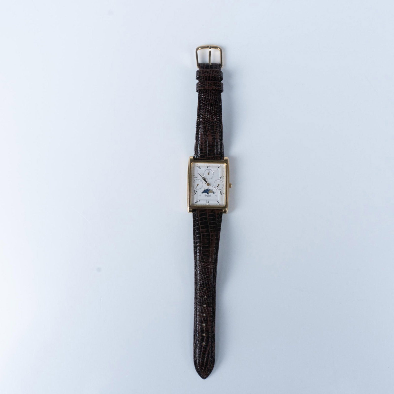 Bulova Golden T1 Moon Phase Calendar Quartz Watch: The gold metal watch has a white face with roman numerals and month, day, and date sub-dials as well as a moon phase tracker. Japan movement. The total length with the brown genuine leather straps is 
