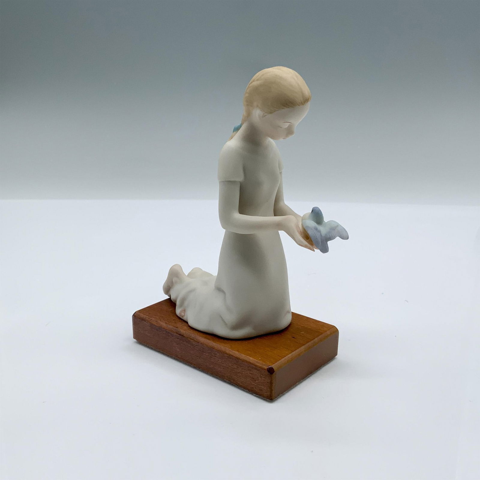 Cybis Porcelain Figurine, First Flight: Fine porcelain figurine of a girl holding a bird. Cybis mark near the base. Artist: Patricia Eakin Issued: 20th c. Dimensions: 3"L x 1.75"W x 4.5"H Manufacturer: Cybis Country of Origin: United Stat