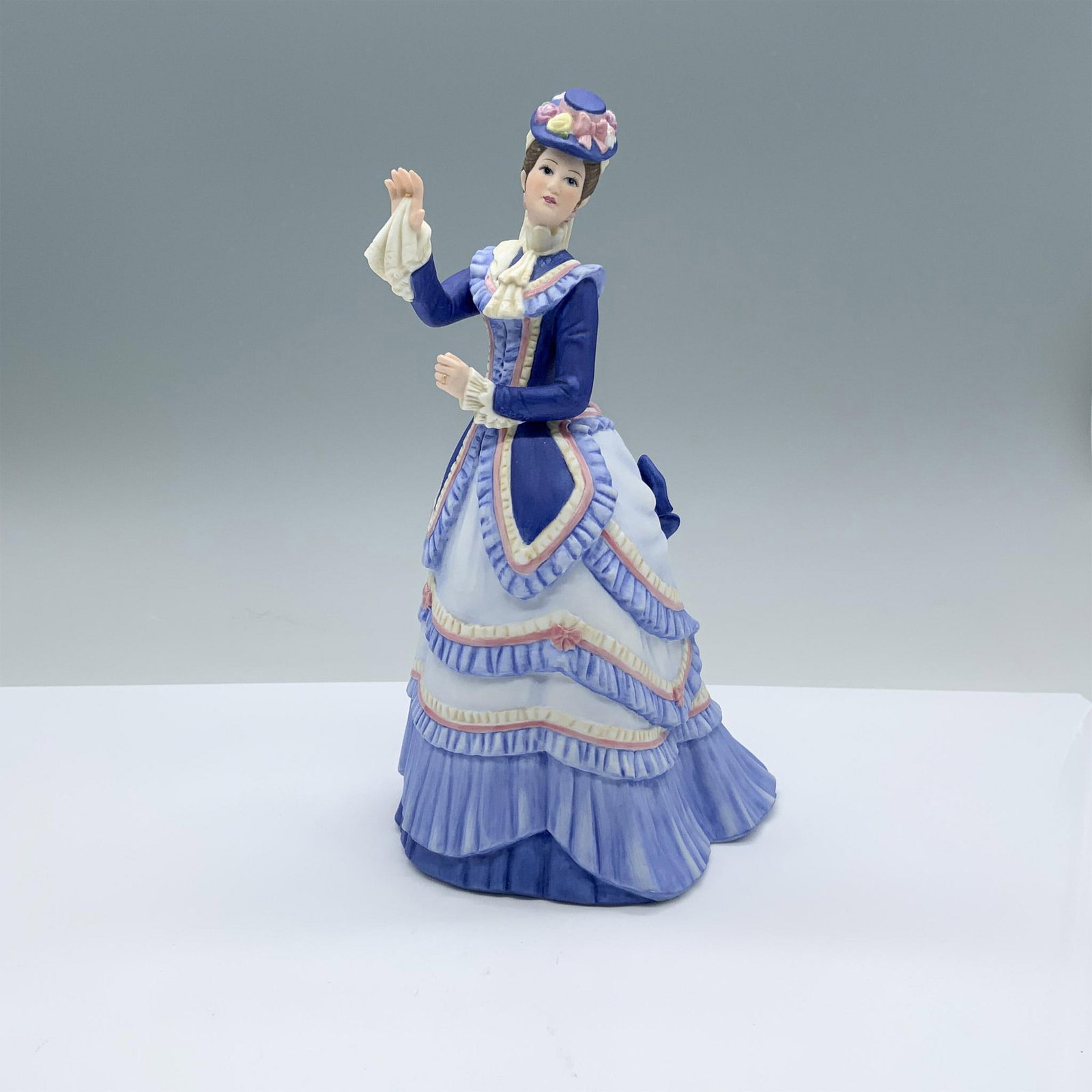 Lenox American Fashion Figurine, Grand Tour: Finely decorated matte porcelain lady figurine with Lenox backstamp on the bottom. Issued: 1986 Dimensions: 5.25"L x 4.5"W x 8.5"H Manufacturer: Lenox