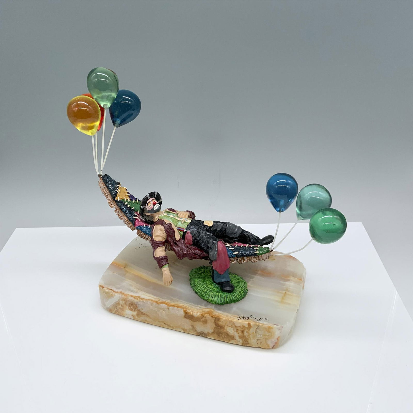 Ron Lee Emmett Dreaming Clown In Hammock Statue Figurine: Limited edition style no. EKJ801. Unique figurine depicts a sleeping clown on a hammock being held up by balloons. Artist signature on the base. Including the balloons, it measures approximately 11.5"