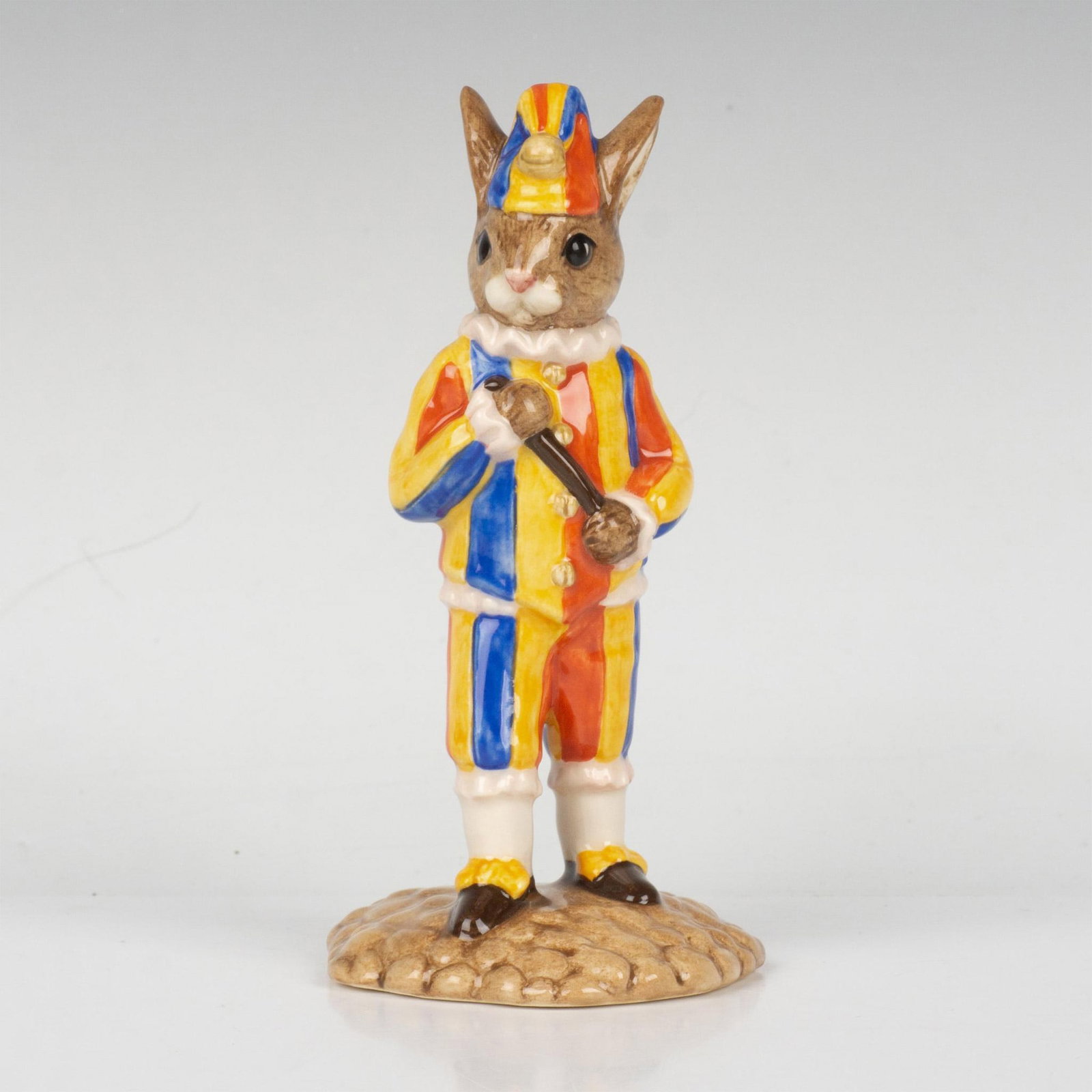 Mr. Punch DB234 - Royal Doulton Bunnykins: A jester wearing a yellow, red, and blue outfit and hat, and is holding a stick. Part of the Punch and Judy Collection. Royal Doulton backstamp. Artist: K. Curtis Issued: 2001 Dimensions: 4.75"H Editi