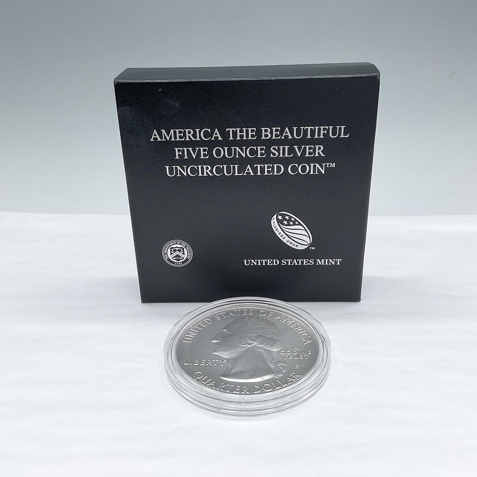 2021-P America The Beautiful 5oz Uncirculated Silver Coin: Philadelphia Mint. The obverse design depicts a portrait of George Washington. The reverse side depicts a Tuskegee Airman pilot suiting up to join the fight during WWII. The coin is in a protective ca