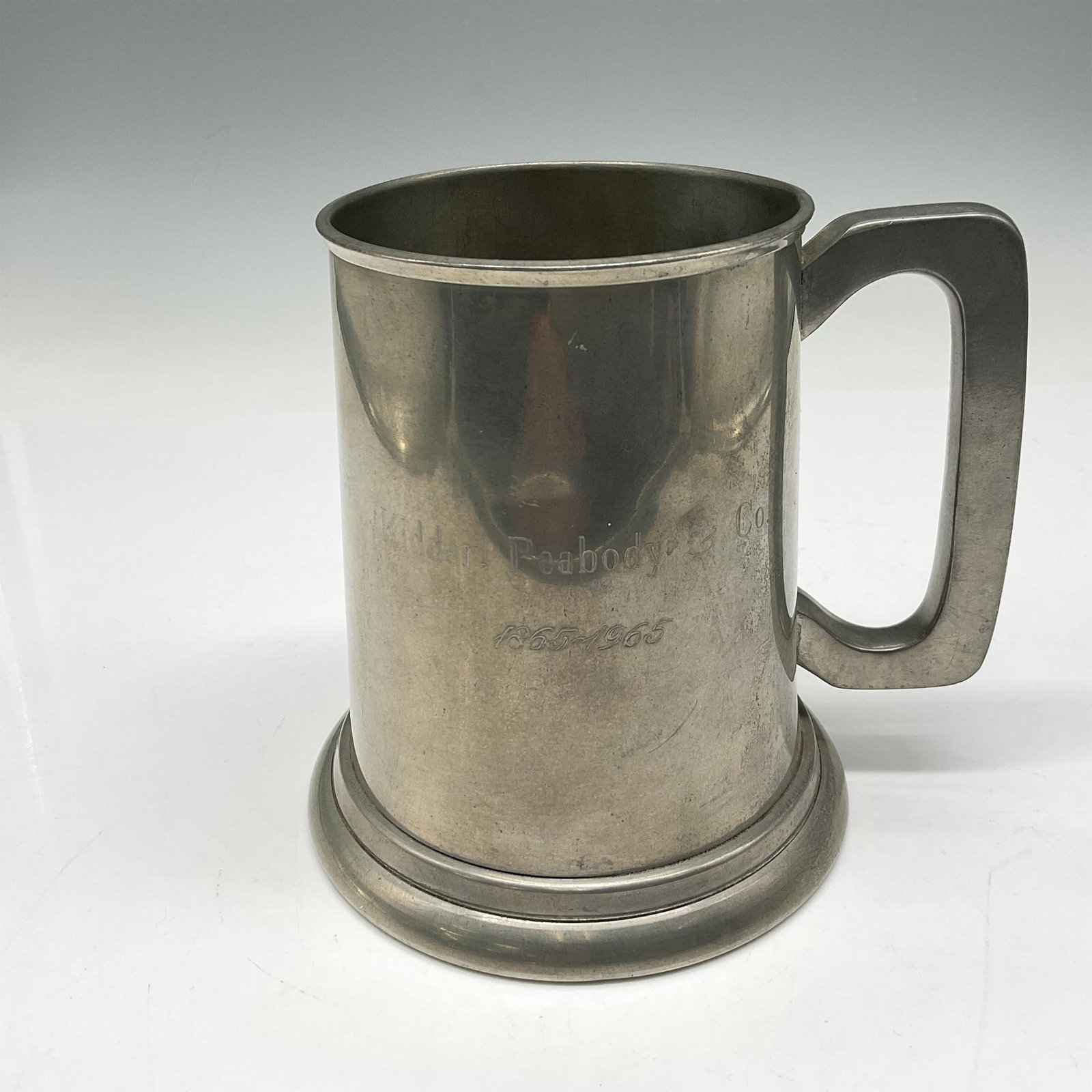 Sheffied Pewter Stein - Kidder, Peabody & Co. 100 yr.: Commemorative glass bottom stein celebrating this Wall Street firms 100-year anniversary. Sheffield impressed mark. Issued: 1965 Dimensions: 5.5"L x 4"W x 5"H Manufacturer: Sheffield Country of Origin