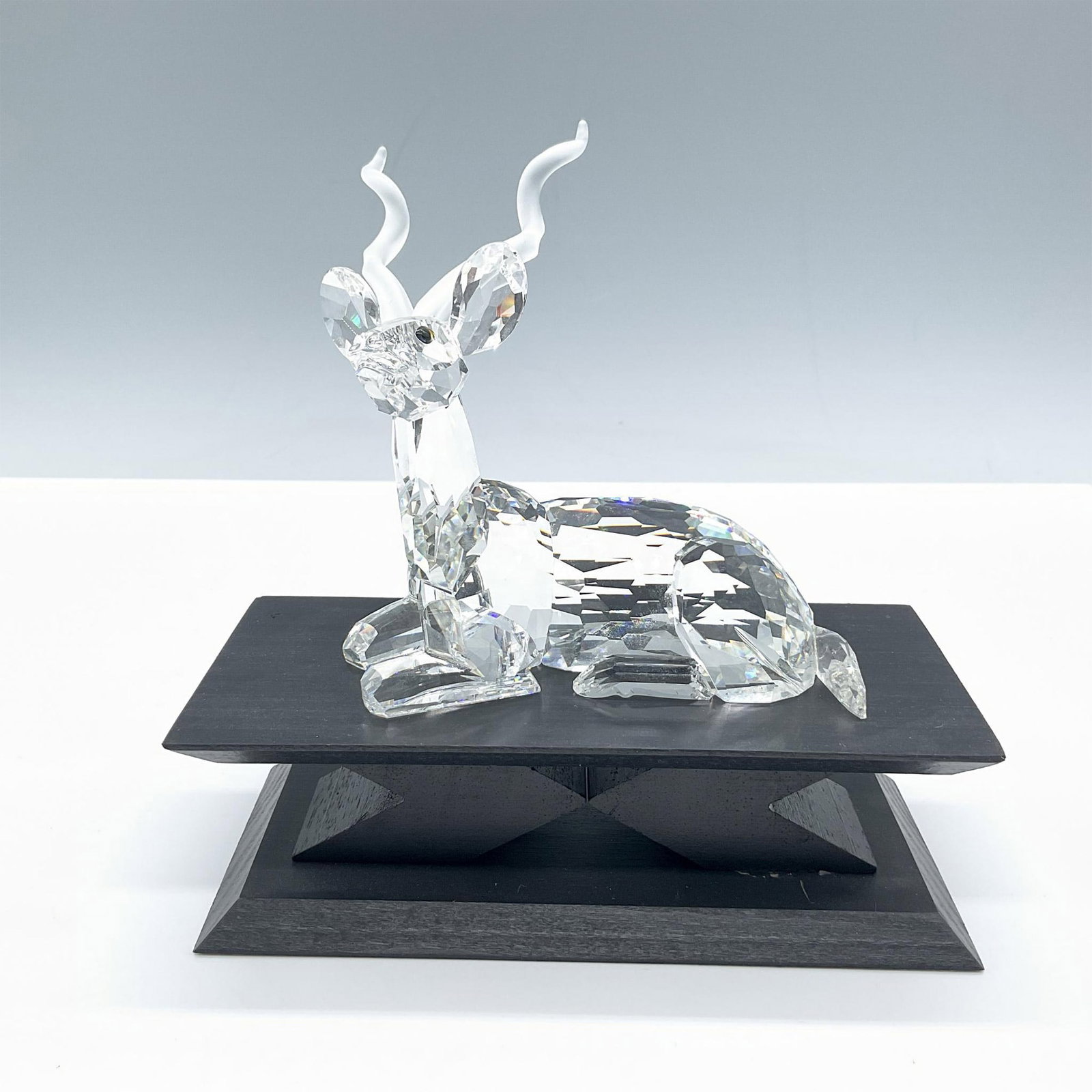 Swarovski Crystal Figurine, The Kudu + Base: From the Inspiration Africa annual edition of 1994. Features a majestic facetted crystal figure with frosted horns. Accompanied by a black base, dimensions: 2.75''L x 6''W x 2''H. The piece includes i