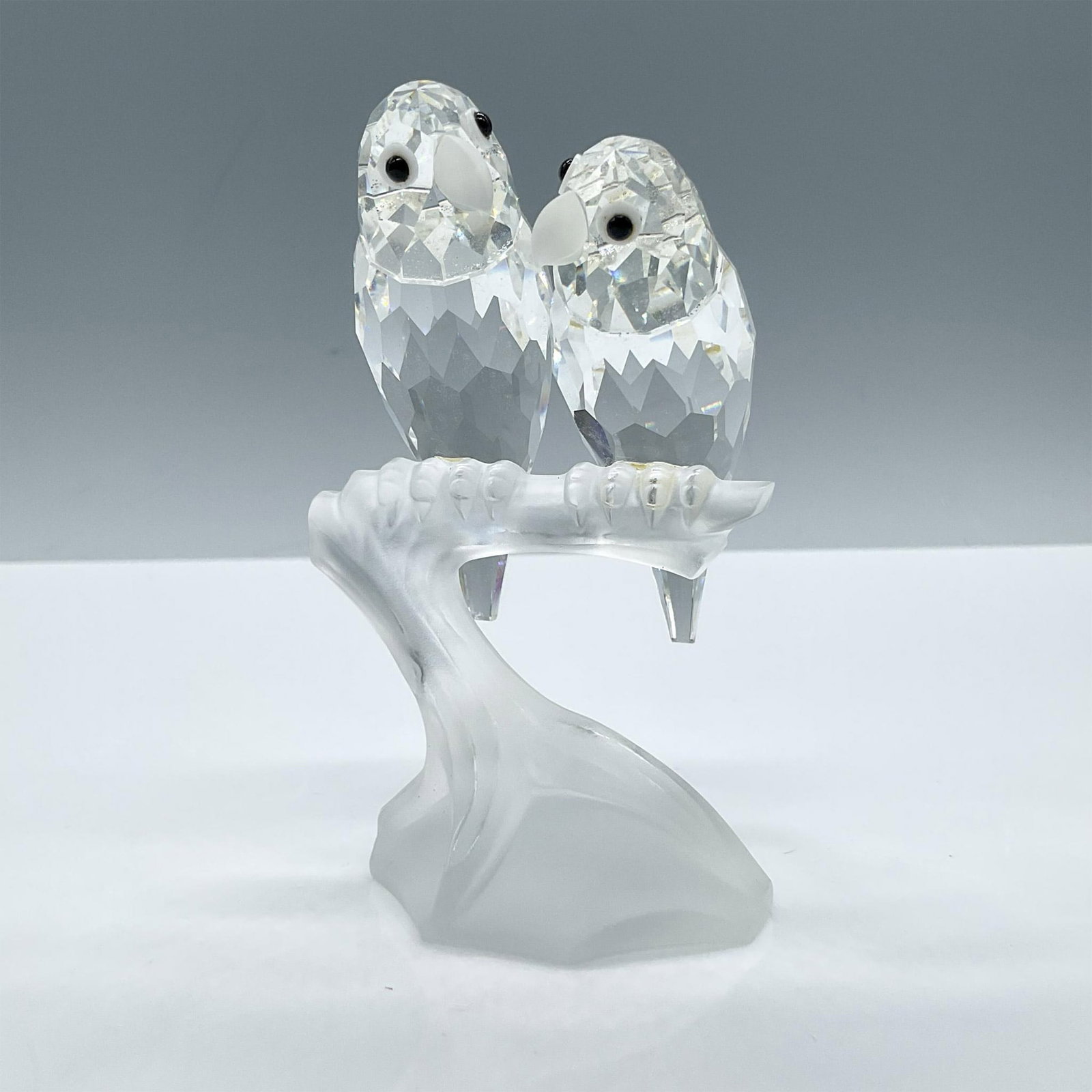 Swarovski Crystal Figurine, Togetherness Lovebirds: From the SCS Annual edition of 1987. Beautiful pair of dazzling facetted clear crustal birds with frosted beaks sitting on a frosted branch. Includes the original box dimensions: 6.75''L x 6''W x 5.5'