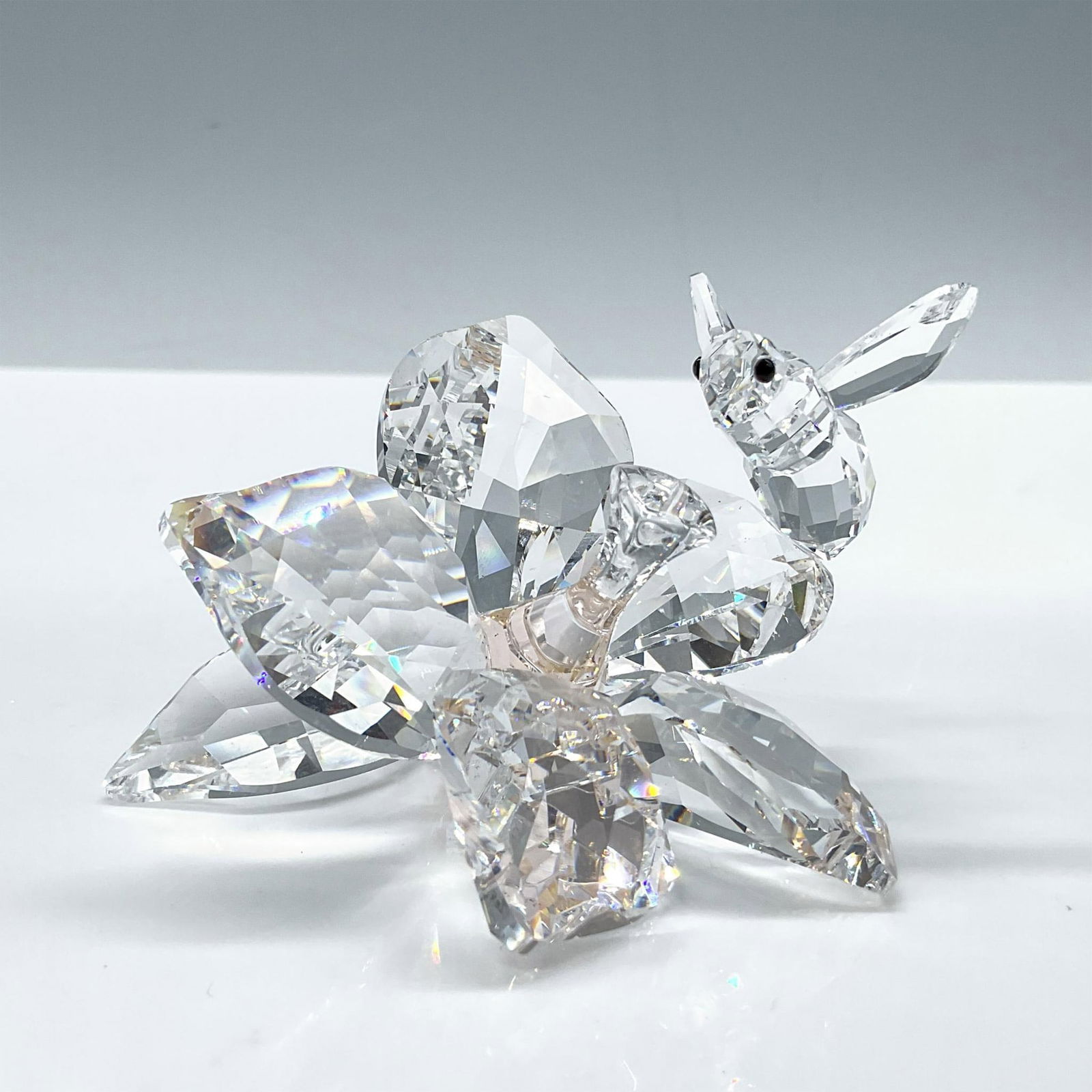 Swarovski Crystal Figurine, The Collector, The Bee: From the SCS 20th Anniversary of 2007. Presents a lovely faceted clear crystal bee on a flower with a light peach crystal stamen. Includes certificate and the original box dimensions: 5.75''L x 5.75''