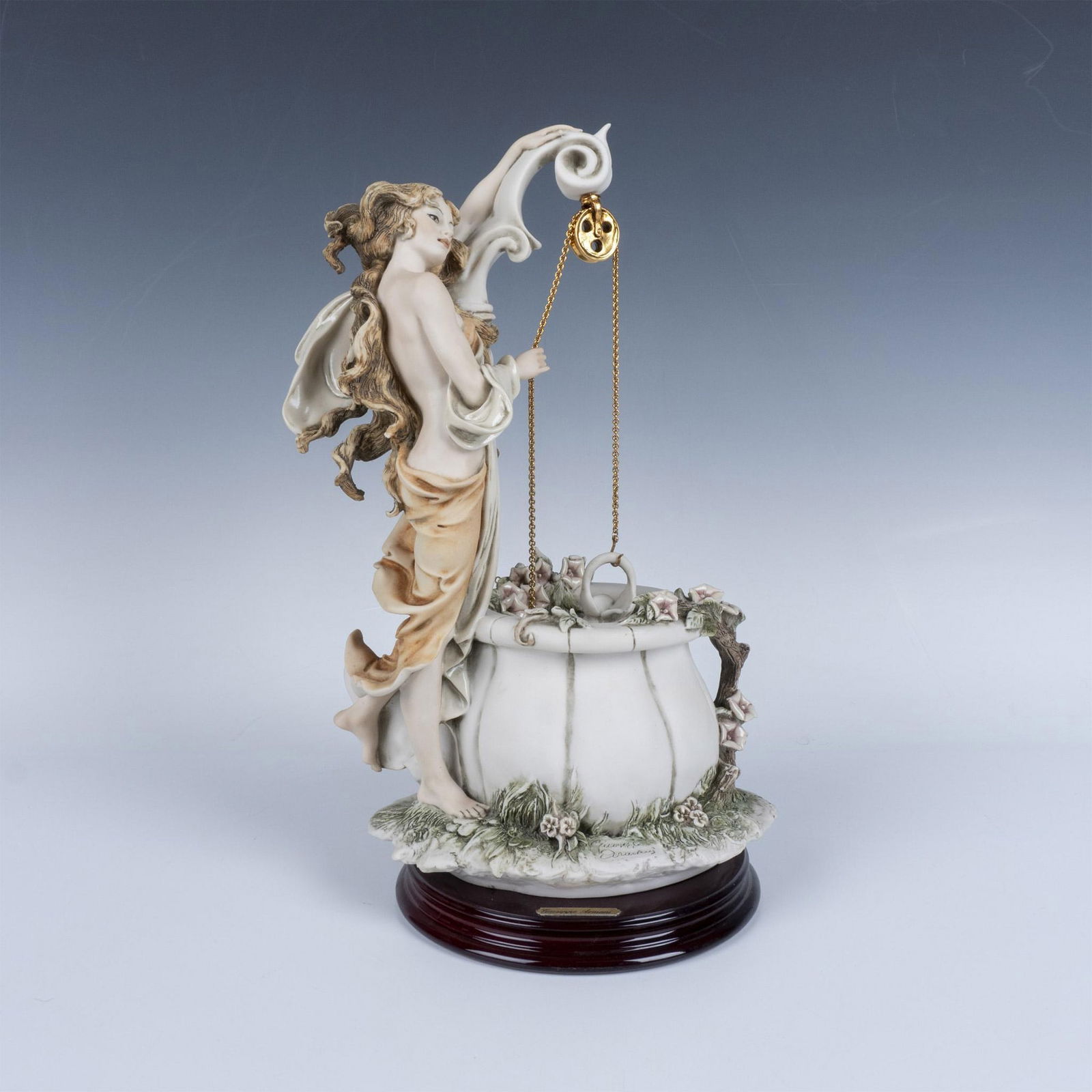 Florence Giuseppe Armani, Girl at the Well Sculpture 246C: Beautiful woman perched beside a flowered well, gathering water. Figure attached to a round base. Giuseppe Armani marked, Capodimonte backstamp and Florence Giuseppe Armani plaque on base. Artist: Giu