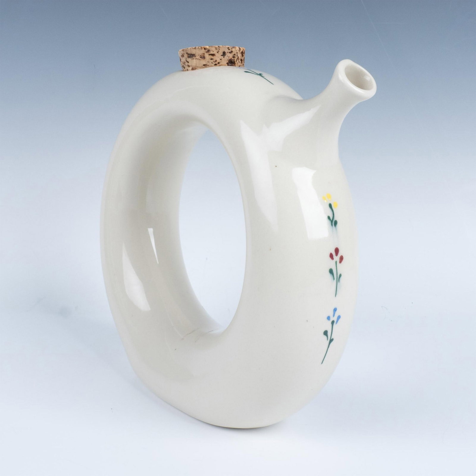 Vintage Hartstone USA Stoneware Circle Wine Decanter Jug: Stoneware donut ring decanter with a painted floral design. Hartstone backstamp on the bottom. Issued: 20th c. Dimensions: Approximately 10.5"L x 3"W x 9.5"H Manufacturer: Hartstone Country of Origin: