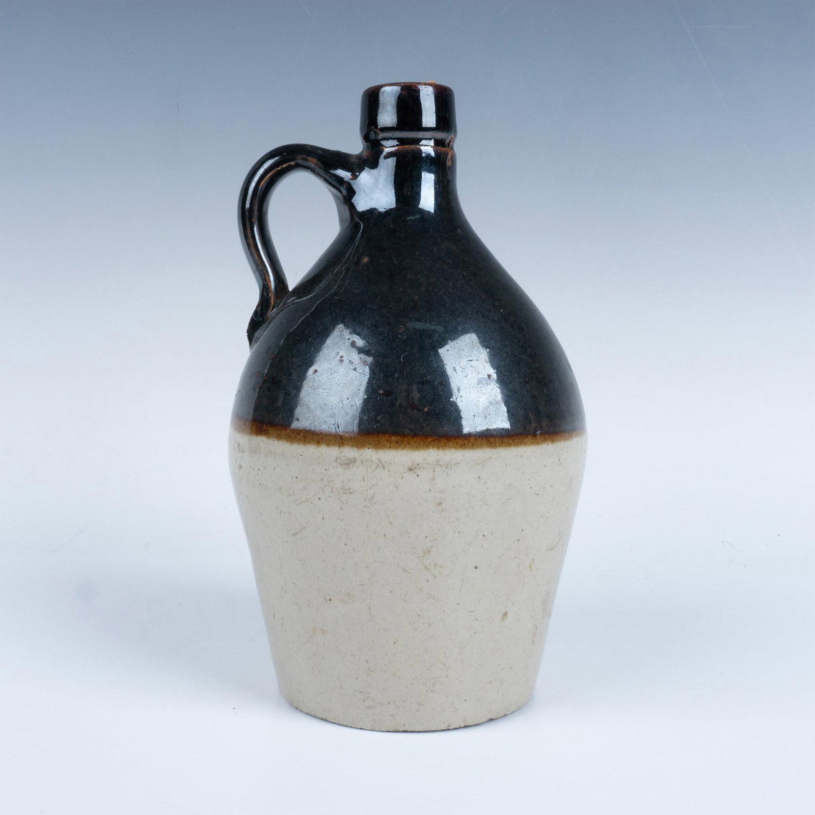 Vintage Two-Tone Stoneware Jug: Old-fashioned stoneware jug with a cork stopper and markings on the bottom. Dimensions: 5"dia. x 8.25"H