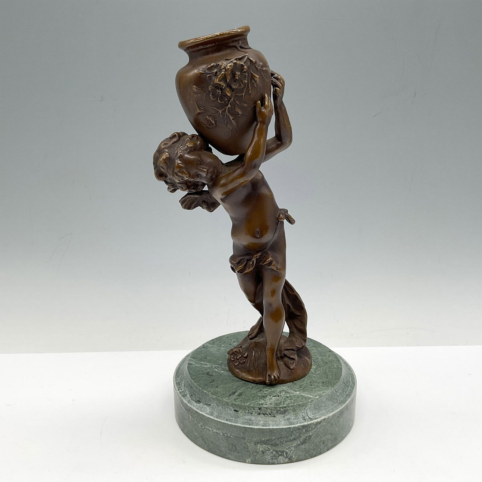 Auguste Moreau (After) 20th Century Cherub Bronze Sculpture: French bronze figure beautifully sculpted carrying urn. Sculpture is mounted on a green marble base. Issued: 20th century Dimensions: 9"H x 4.5" dia.