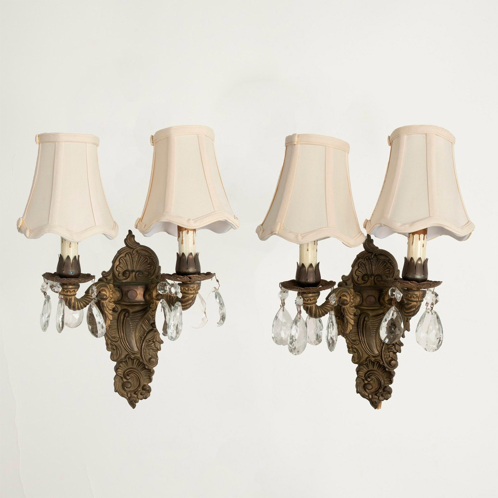6pc Pair of Vintage Bronze Dual Arm Wall Sconces: Designed bronze with florals and shells with twisted lighting arms accented by glass drop crystals. Two fabric lampshades per sconce included 5.25"H x 5" dia. Issued: 20th century Dimensions: 14.5"L x