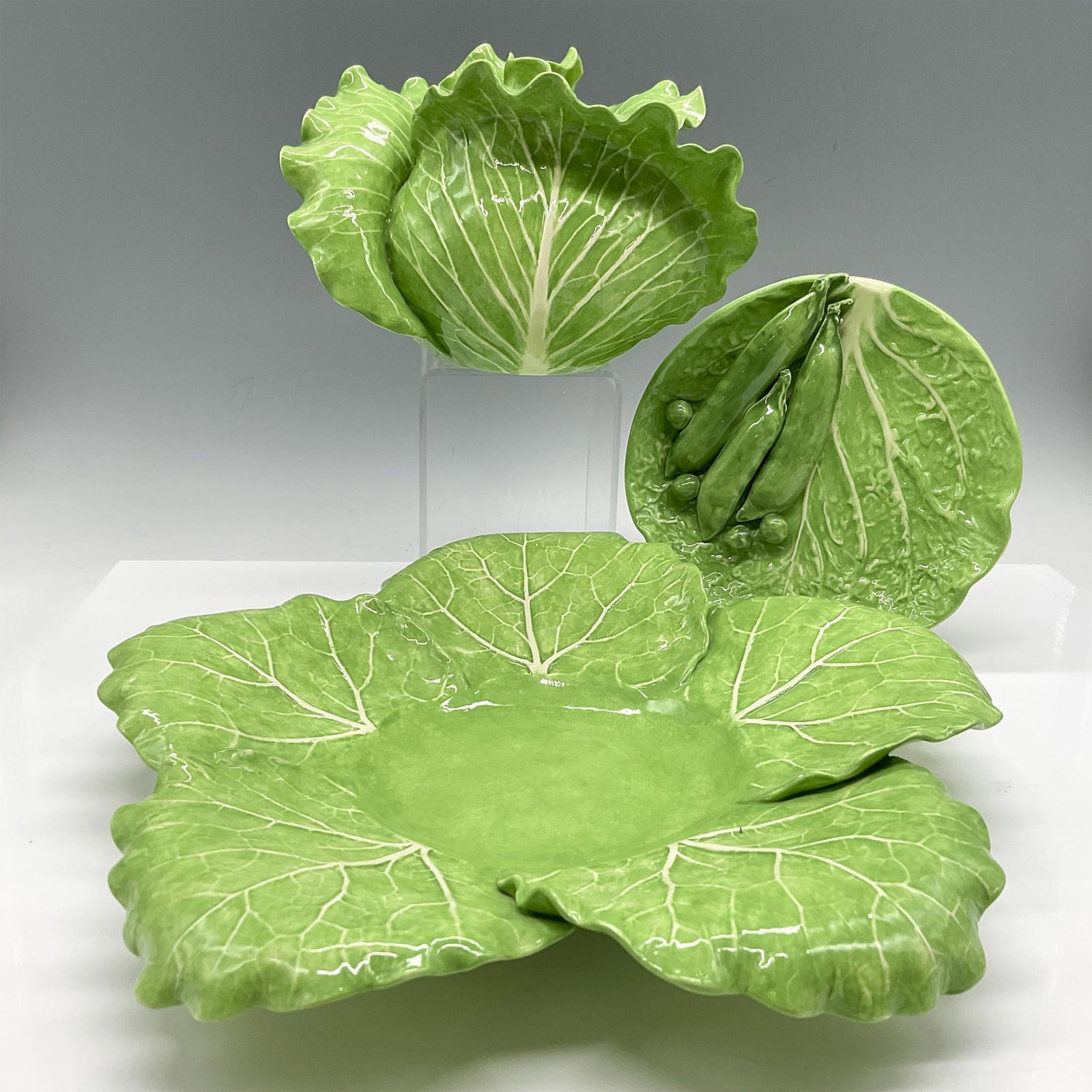 4pc Dodi Thayer Ceramic Lettuce Design Serve Ware Set: Florida artist Dodi Thayer created unique dining pieces. Lot includes round lettuce platter (2"H x 11" dia.), condiment dish (0.75"H x 6" dia.) and covered dish (4.25"H x 6.5" dia.). All colored in vi