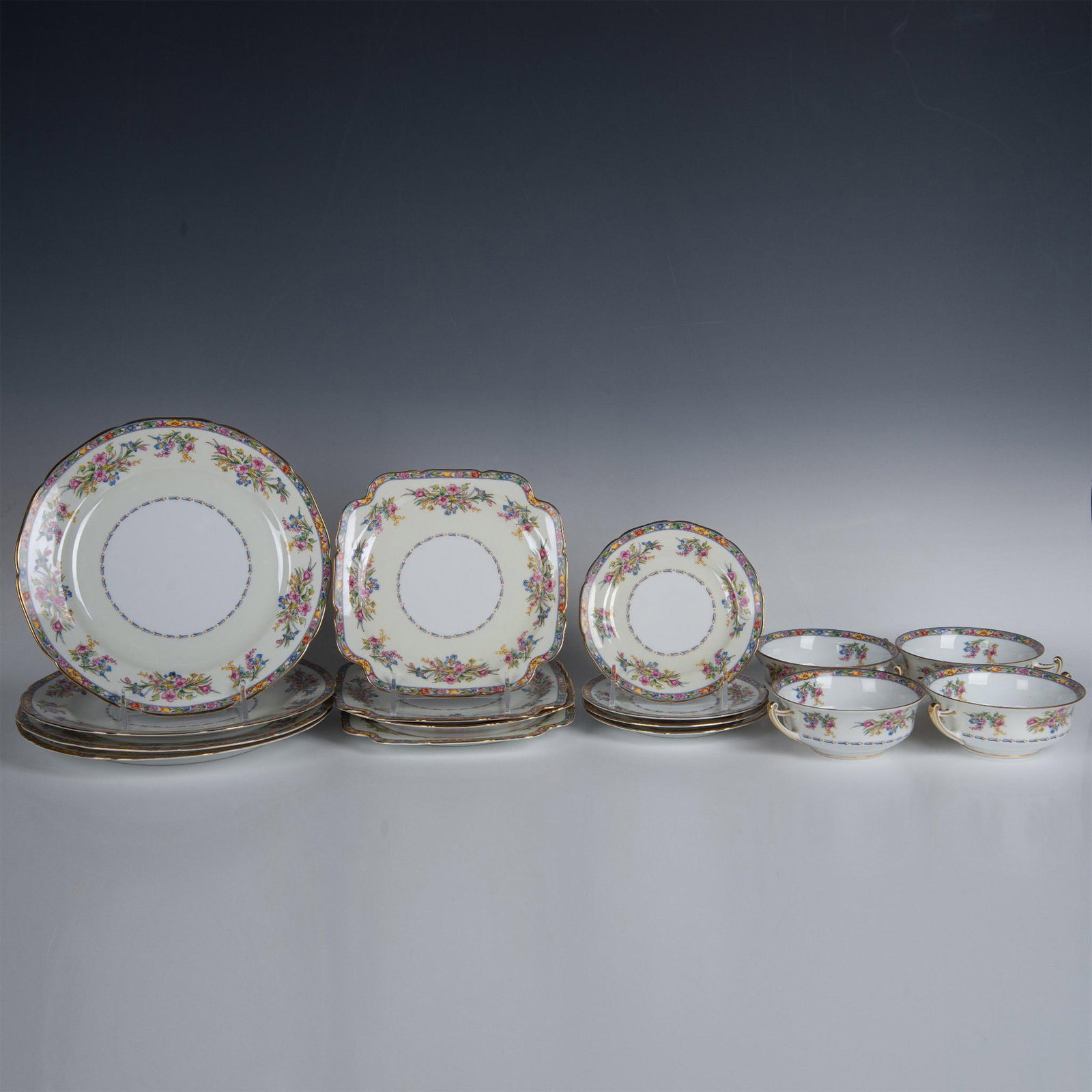 16pc Epiag Porcelain Dinner Set, Service for 4: Lovely floral design colored in blue, pink, yellow and green with gilt edges. Set includes 4 Dinner plates (10" dia.); 4 bread plates (6.25" dia.); 4 square side or underplates (8"L x 8"W x 0.75"H); a