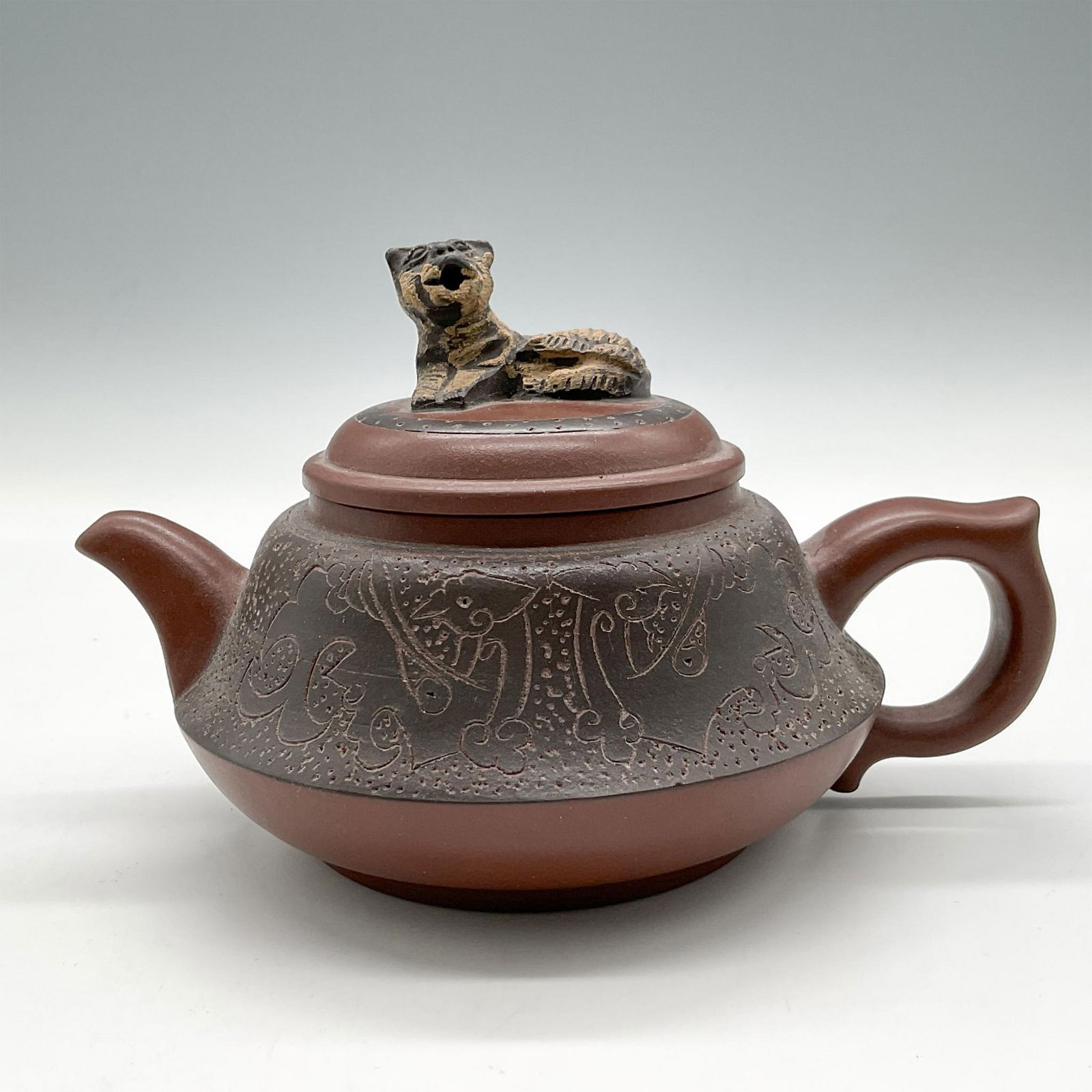 Asian Clay Teapot with Cat-Dragon Lid: Pot has incised design on circumference with unique lid showing happy cat as handle but when lid is lifted revealing a dragon on the reverse. Unidentified ogo impressed mark. Issued: 20th century Dime