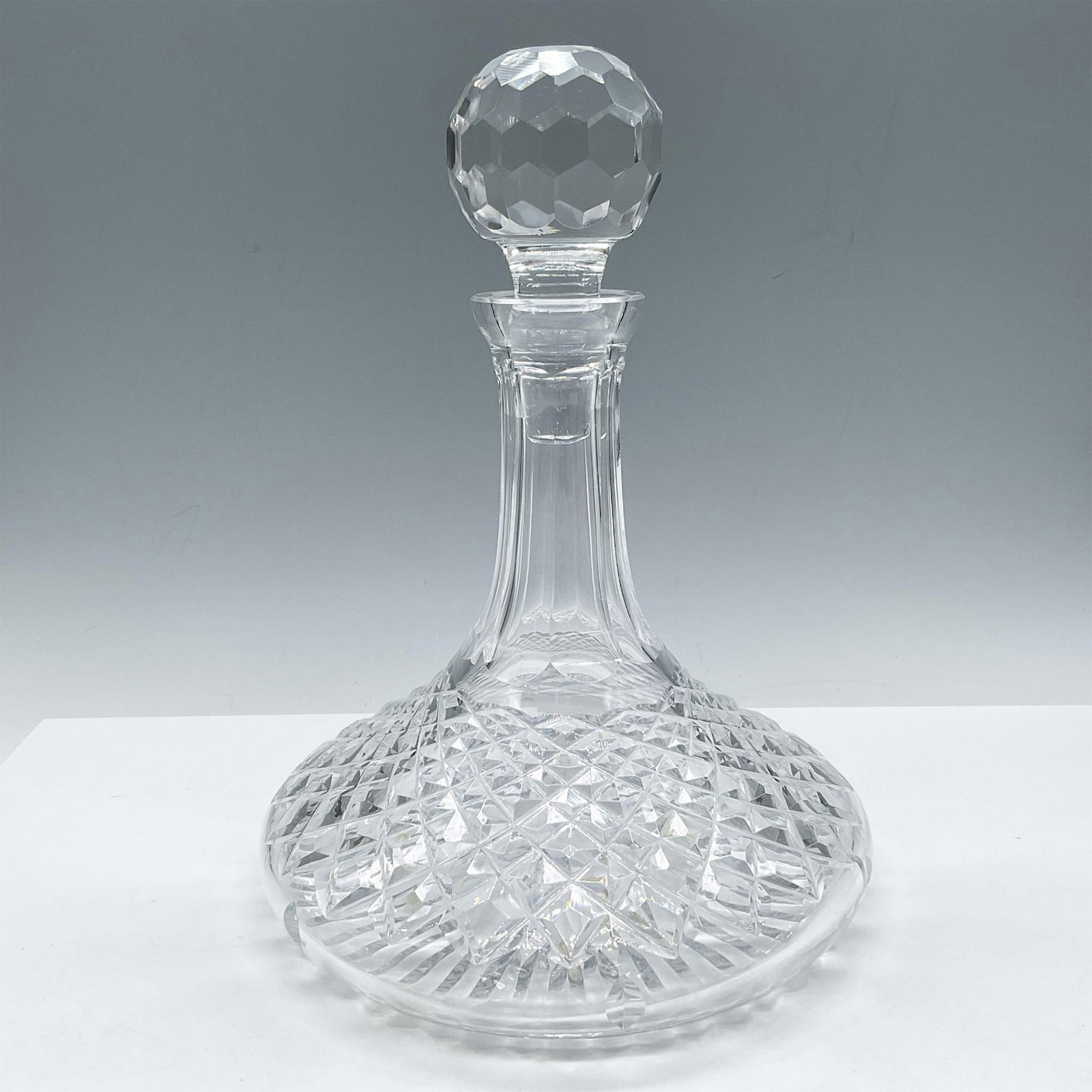 Waterford Styled Crystal Ships Decanter and Stopper, Colleen: This blown glass was designed with short stem and wide bowl with diamond tiered cuts. Round stopper has polygon cuts. Issued: 20th century Dimensions: 10"H x 7.5" dia. Country of Origin: Ireland