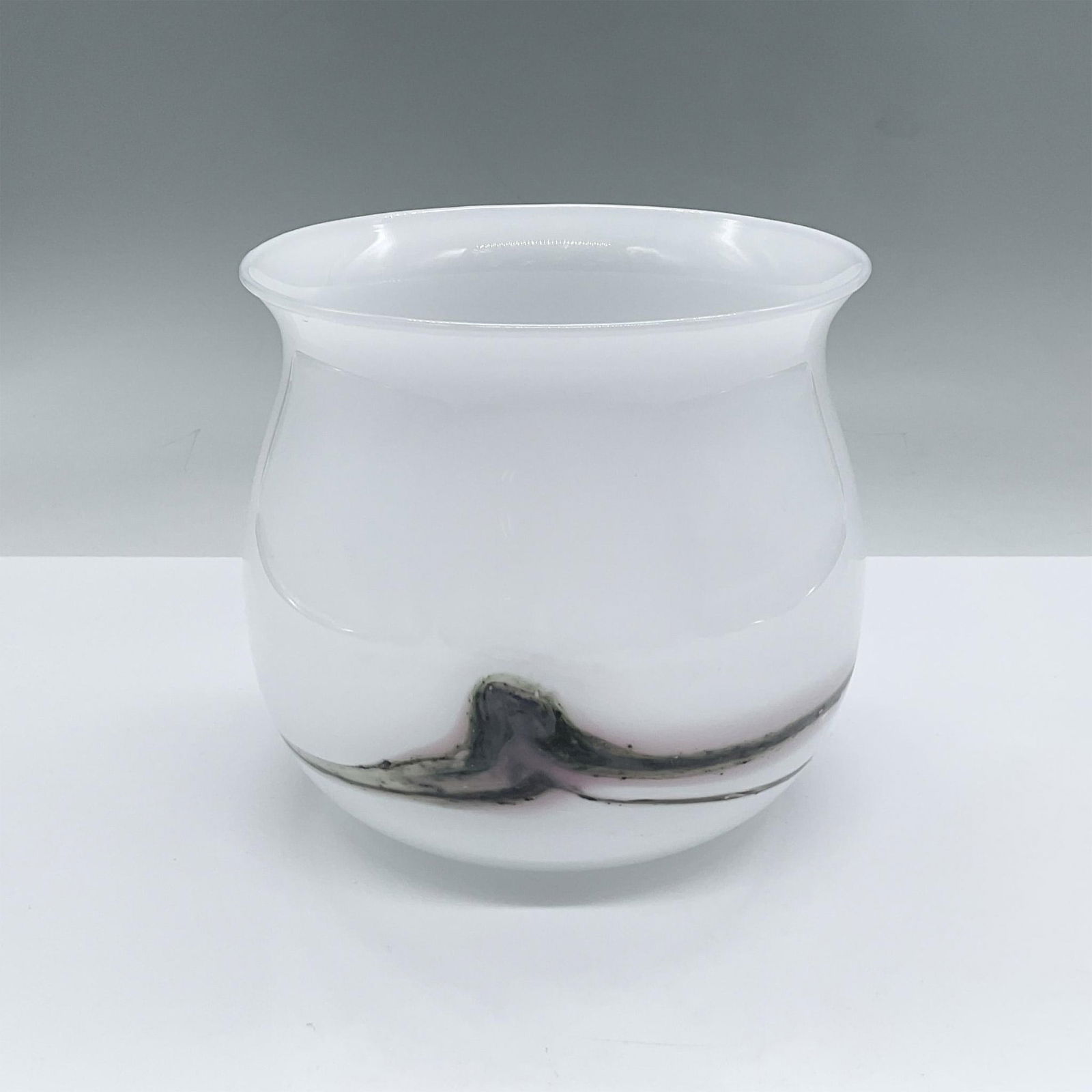 Holmegaard Glass Vase: Opaque white glass vase adorned with a grey and rose swirled ring around the base. Issued: 20th century Dimensions: 5"H x 5.25"dia. Manufacturer: Holmegaard Country of Origin: Denmark