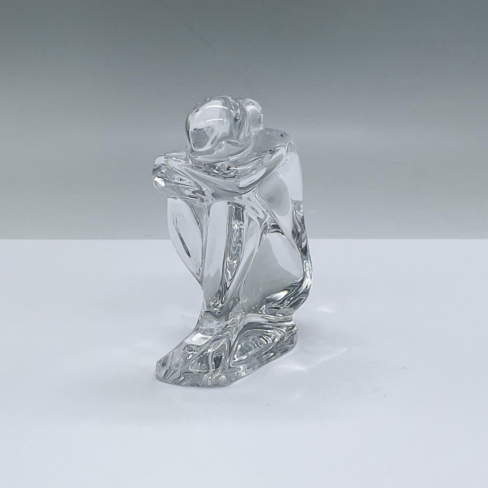Robert Rigot for Baccarat Crystal Statuette, Female Seated Nude: Clear crystal sculpture of a nude seated female. Her legs are crossed and her head is resting on crossed arms which are resting on her knees. Simple elegance. Baccarat backstamp and artist signed. Thi