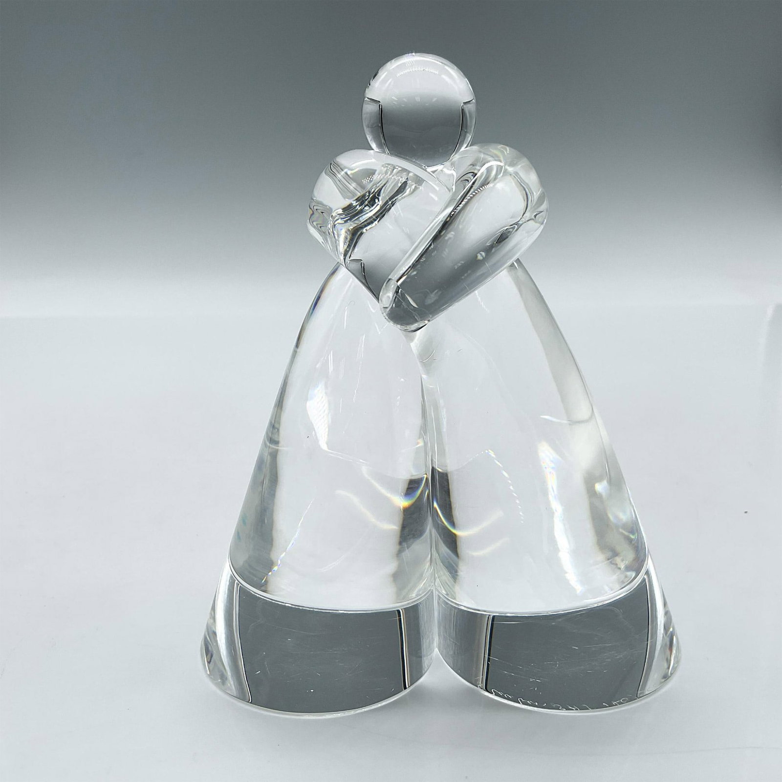 Steuben Art Glass Figurine, Embracing: Limited edition clear glass sculpture in embrace. Steuben SHS etched mark. Issued: 20th century Dimensions: 4"L x 2.25"W x 4.75"H Edition Number: 140 of 500 Manufacturer: Steuben Country of Origin:</