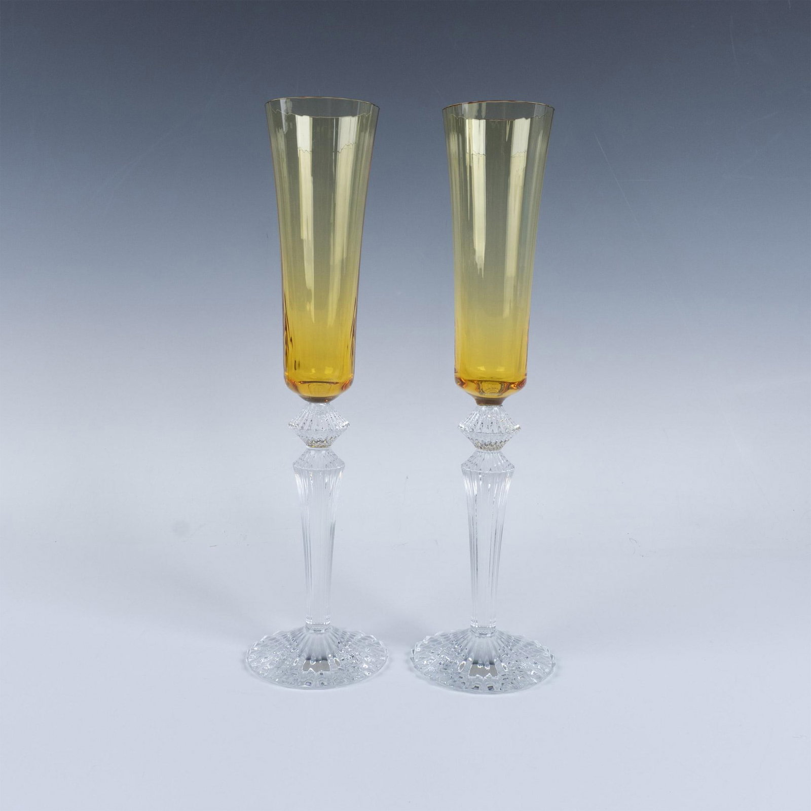Pair of Baccarat Crystal Amber Champagne Flutes, Mille Nuits: Elegant duo of tall clear and amber crystal in the Mille Nuits pattern. Baccarat engraved signature. Signed Mathias. Artist: Mathias Issued: 20th century Dimensions: 11.5''H x 3''dia, Each Manufacture