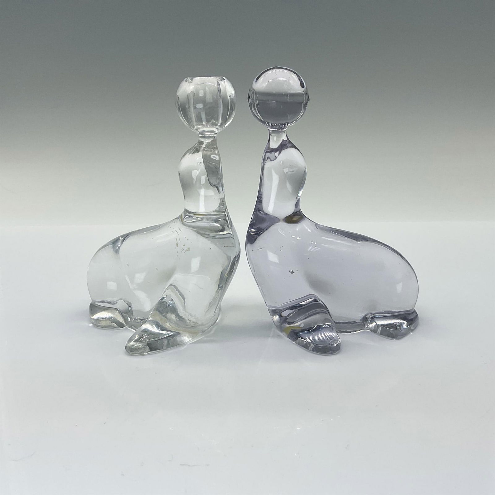 2pc New Martinsville Seals Candle Holder and Paperweight: This pair includes one with a candle holder and the other figurine or paperweight is balancing a ball on his nose. Issued: 20th century Dimensions: 3.5"L x 2.75"W x 4.75"H