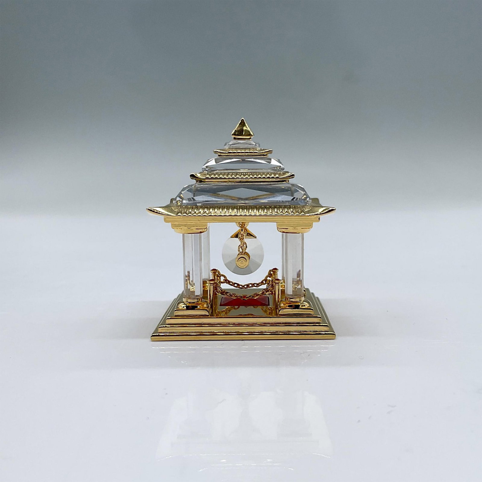 Swarovski Crystal Figurine, Japanese Temple 243447: This rare retired Swarovski Japanese temple is clear faceted crystal with golden metal accents. Swarovski impressed mark on the bottom. It comes in its original box, which measures 4"L x 4"W x 2.5"H. 