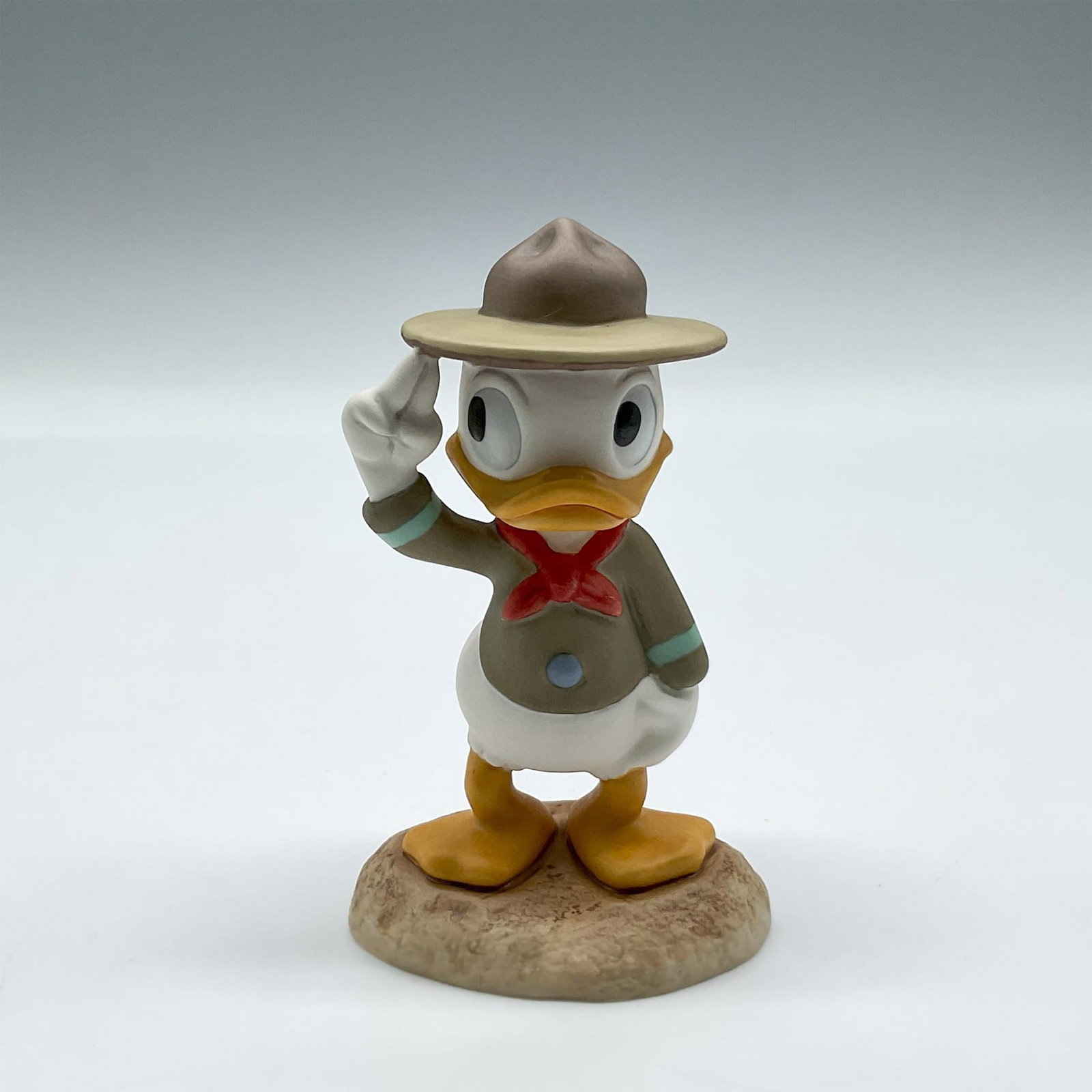 Walt Disney Figurine Collection, Good Scouts A Real Trooper: Collectors Society members only figurine, Nephew Duck, dressed in his scout's uniform, colored in brown, cream, and green. Walt Disney Collection backstamp. 4007936. This item has its original box: 6"