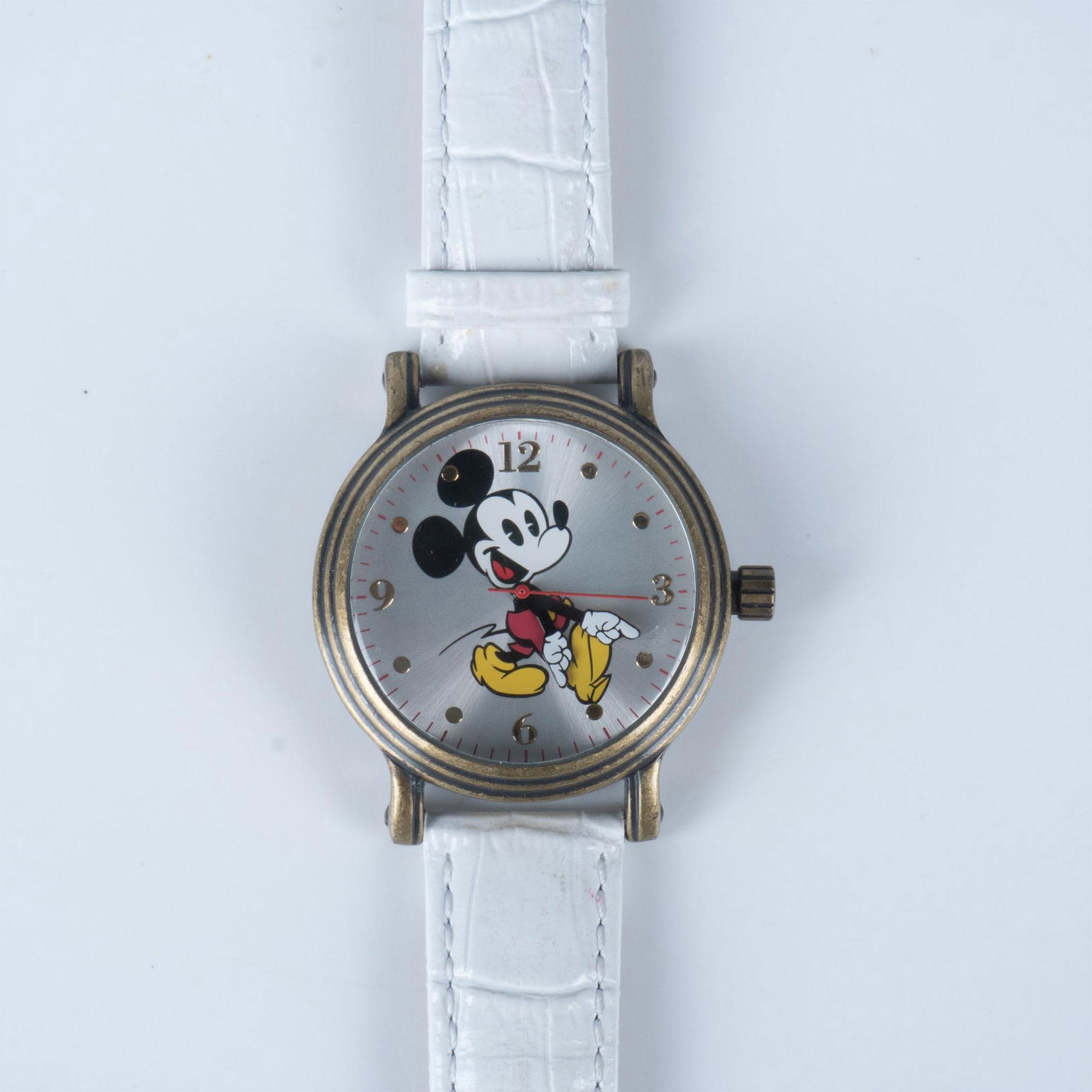 Walt Disney Mickey Mouse Collectors Watch: This unique Mickey Mouse watch was licensed by Disney and made by Ewatchfactory. It has a vintage style brass tone metal case and a white genuine leather band. The total length with the straps is 9.75