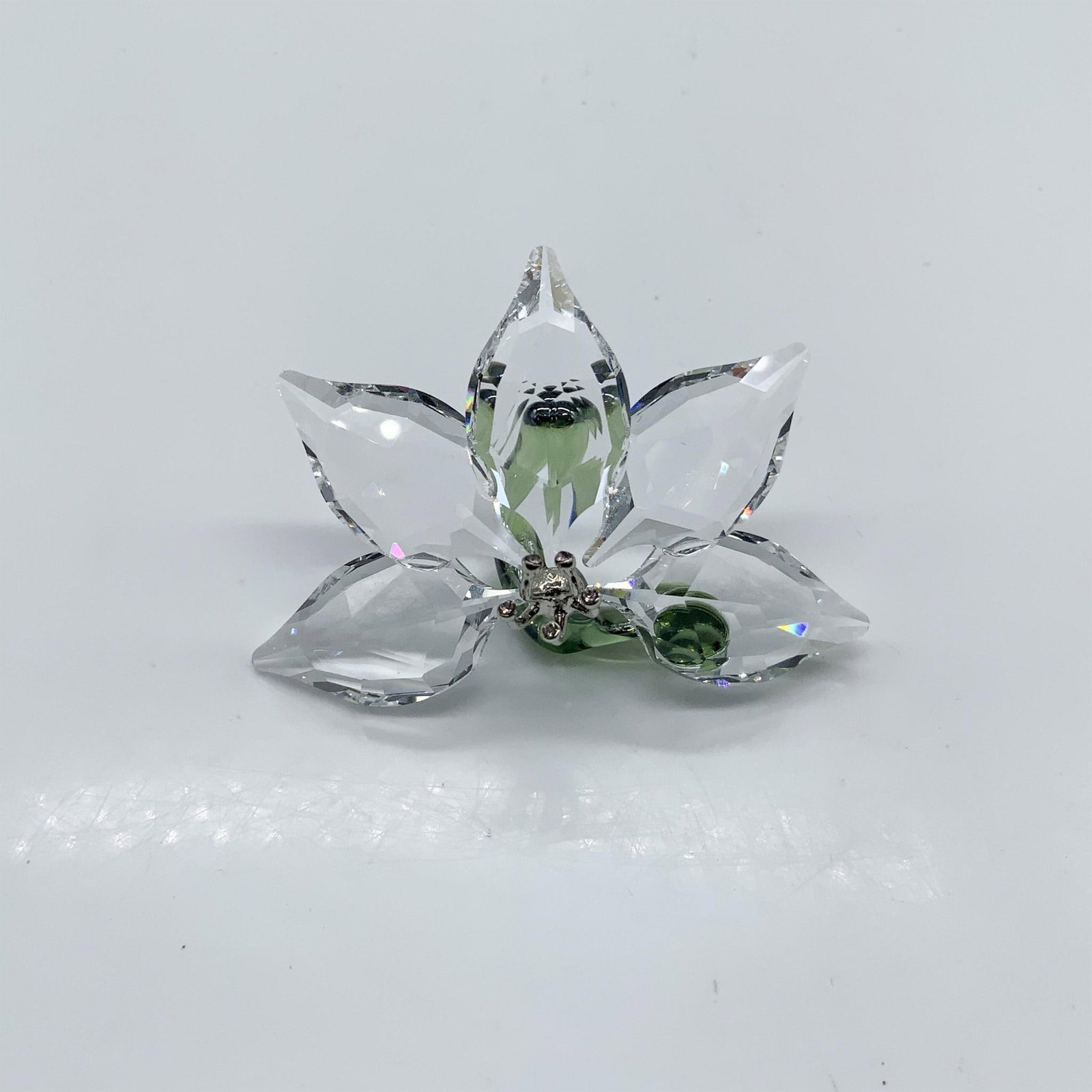 Swarovski Crystal Society Figurine, Orchid 1142858: SCS Members in 2013, received this Swarovski Crystal Orchid as a gift. Clear faceted petals with a green stem and silver metal center. Swarovski acid mark. It comes in its original box, which measures