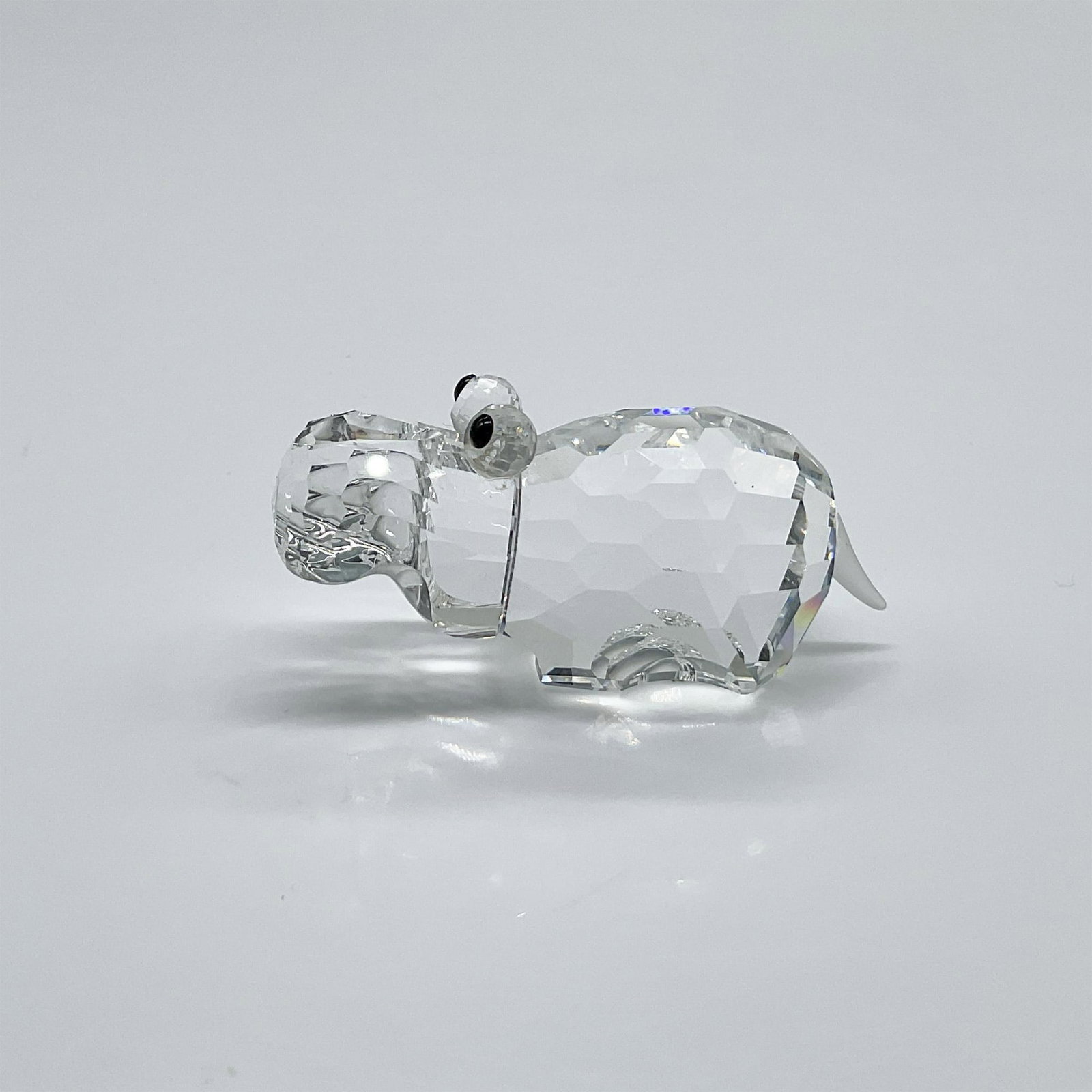 Swarovski Crystal Figurine, Hippopotamus: Part of the African Wildlife collection. A clear crystal hippo with black eyes and frosted tail. Swarovski swan mark. This item has its original box: 3.25"W x 5"H. Artist: Adi Stocker Issued: 1989 - 1