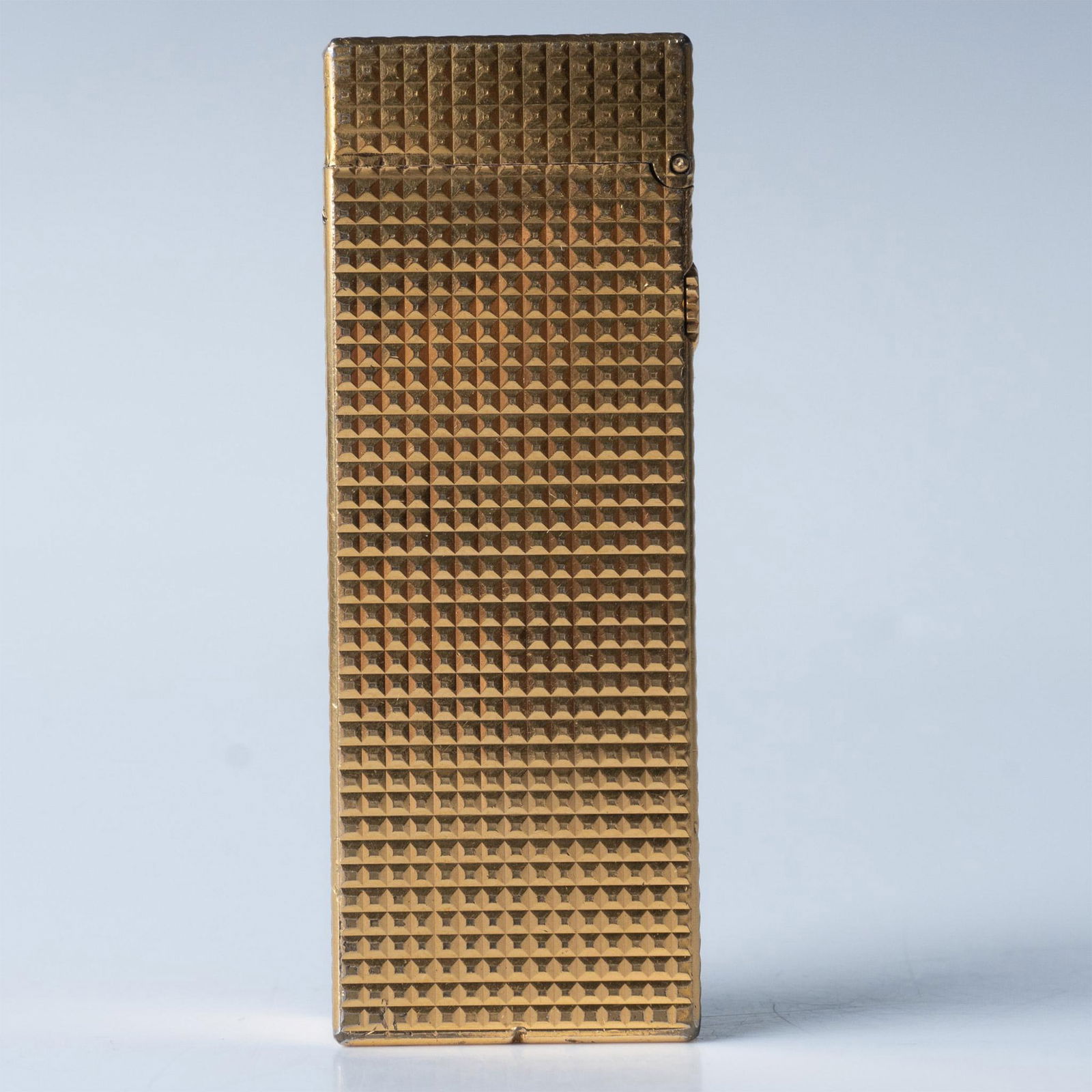 Dunhill Vintage Golden Rollagas Lighter: This Swiss-made textured gold metal lighter comes with its original box which measures 5"L x 4.5"W x 1.5"H. Issued: 20th c. Dimensions: 1"L x 0.5"W x 2.5"H Manufacturer: Dunhill