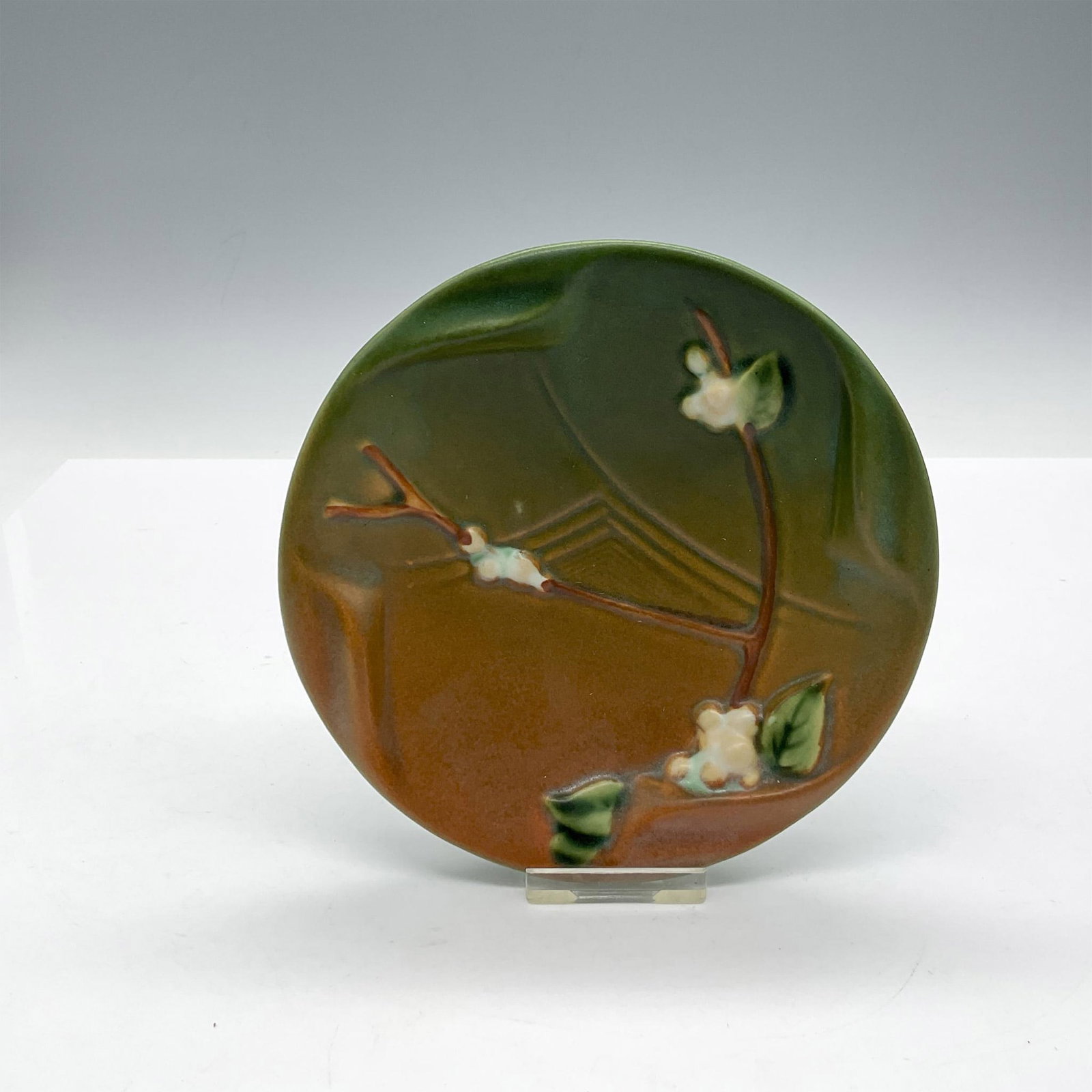 Roseville Pottery Round Dish, Snowberry: Variegated green to tan colored design with raised branch and flowers. Roseville USA impressed mark. Issued: c. 1947 Dimensions: 1.25"H x 5.25" dia. Manufacturer: Roseville Country of Origin: United S