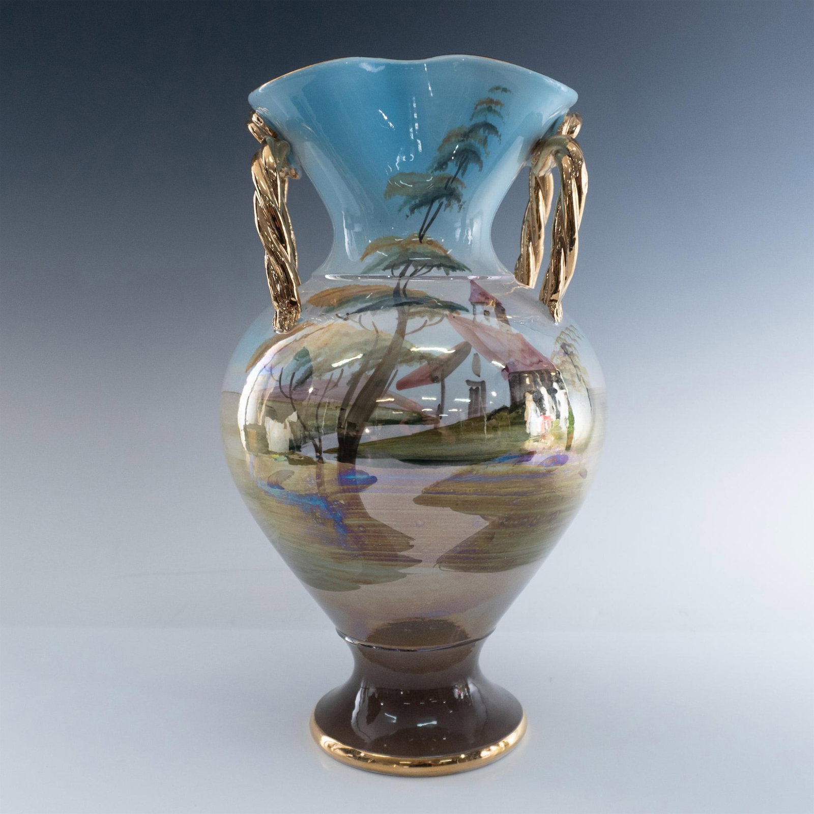 Vintage Italian Hand Painted Porcelain Vase: Lovely urn styled vase with iridescent finish over pale blue designed with landscape and water scene. Vase is accented by gilded handles, rim and base. Made in Italy 400 mark. Issued: 20th century Dim