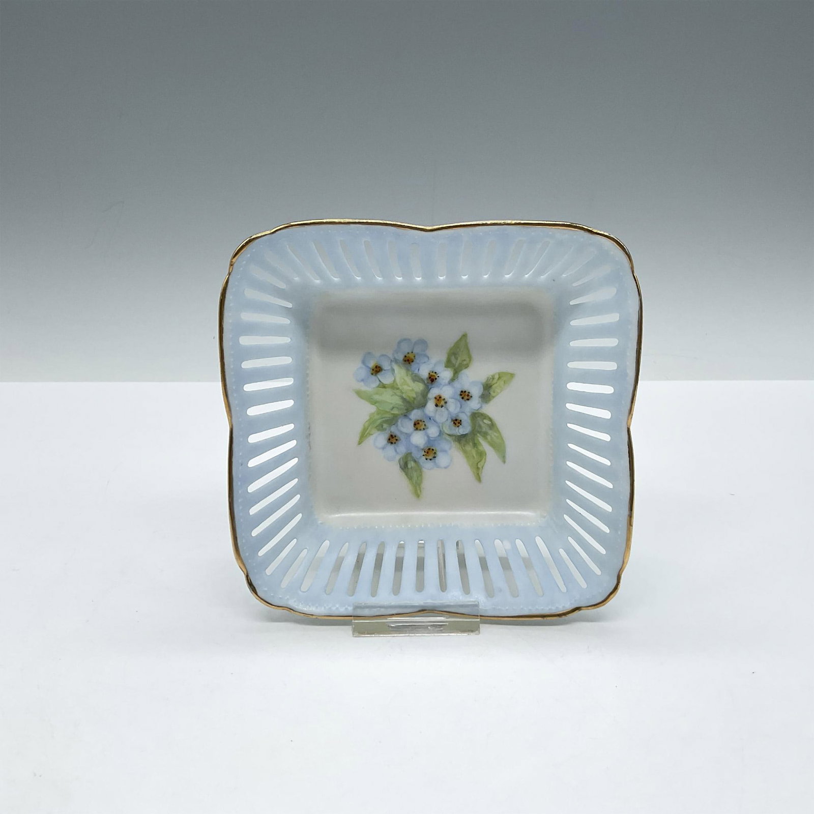 Margaritas Porcelain Basket Trinket Dish: White basket design colored in light blue with Margaritas floral design on center with gilt banding on rim. Issued: c. 2003 Dimensions: 5"L x 5"W x 1.5"H