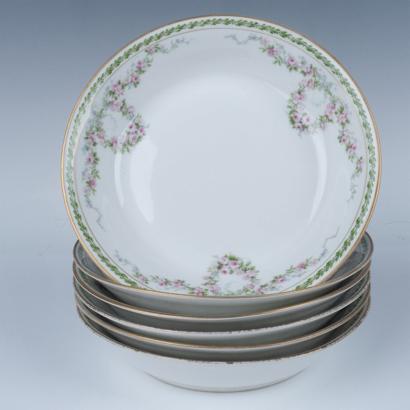6pc Charles Field Haviland Porcelain Soup Bowls: A set of 6 white bowls adorned with pink-blue floral, and laurel garlands around the boarder. GOA Haviland, and Charles Field Haviland Limoges France backstamps Issued: c. 1941 Dimensions: 7.5"W x 1.5