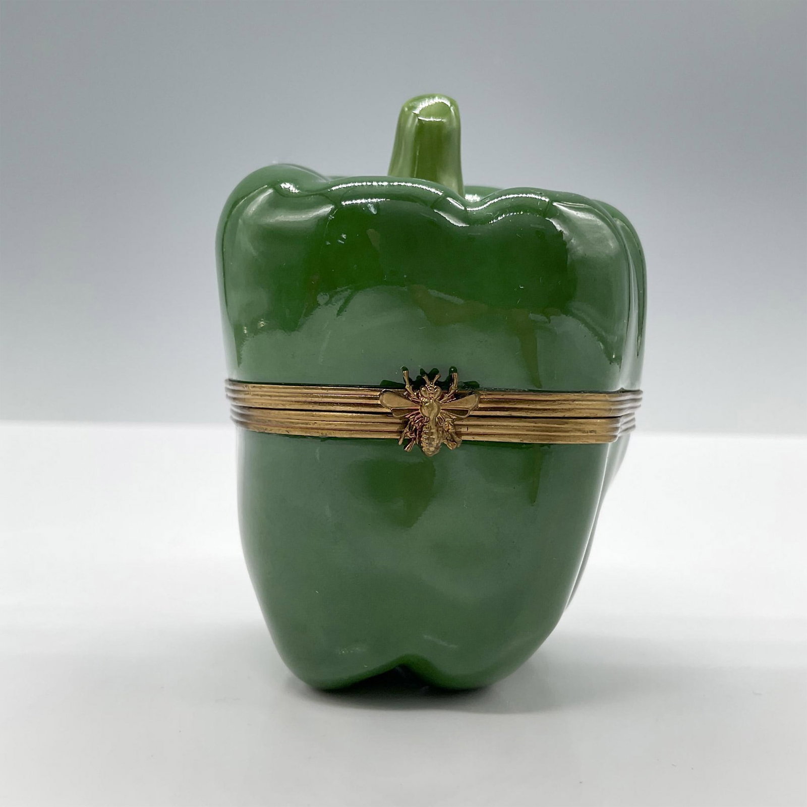 Limoges Porcelain Treasure Box, Green Bell Pepper: Hand painted in Limoges France, this is a limited edition. Adorned with a gold metal closure. Signed V.A Peint Main Limoges France M.B 2000 14/50. Issued: 2000 Dimensions: 2''L x 2.75''W x 3''H Editio